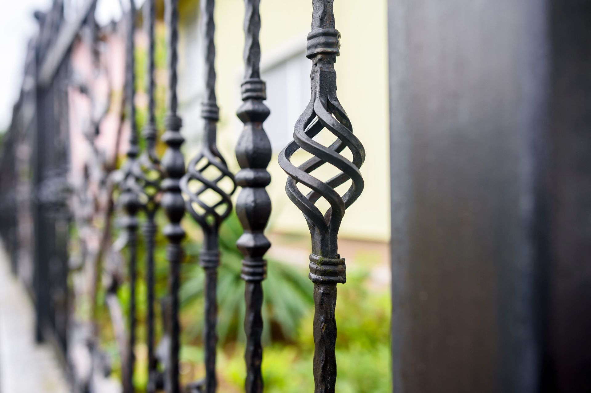 Close up of an ornate wrought iron fence with decorative swirls and spikes