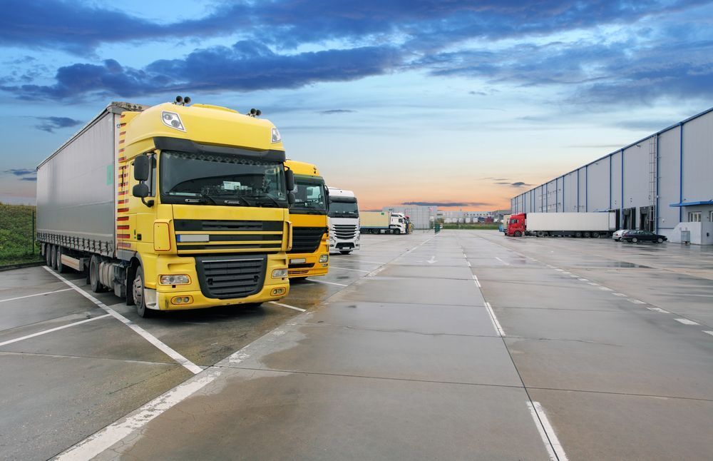 A Row of Yellow Semi Trucks Are Parked in a Parking Lot — R2B Heavy Vehicle Driving School In Paget, QLD