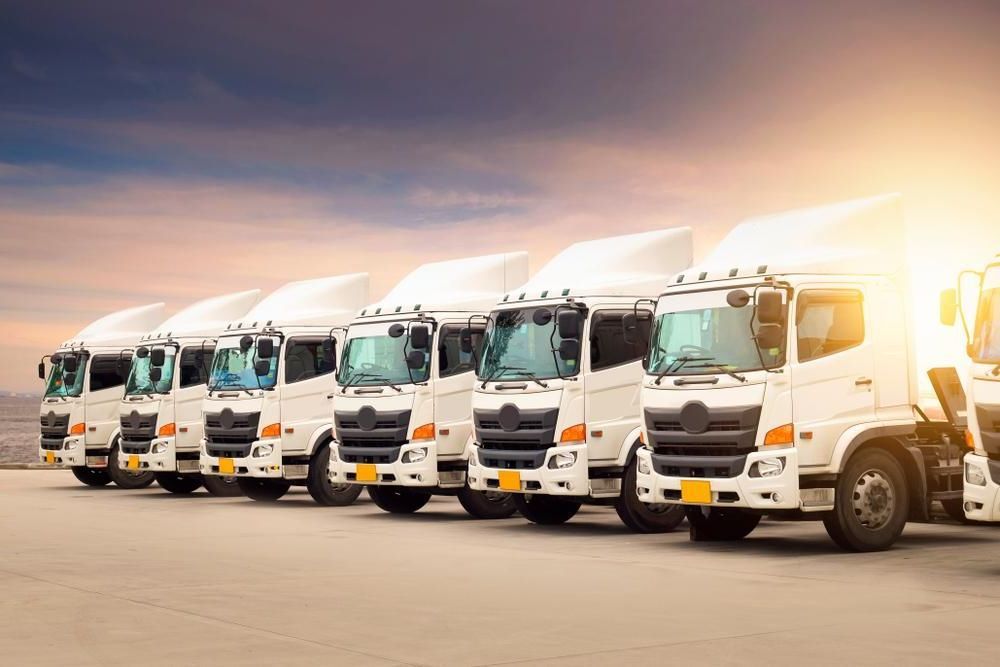 A Row Of White Semi Trucks Are Parked In A Parking Lot — R2B Heavy Vehicle Driving School In Mackay, QLD
