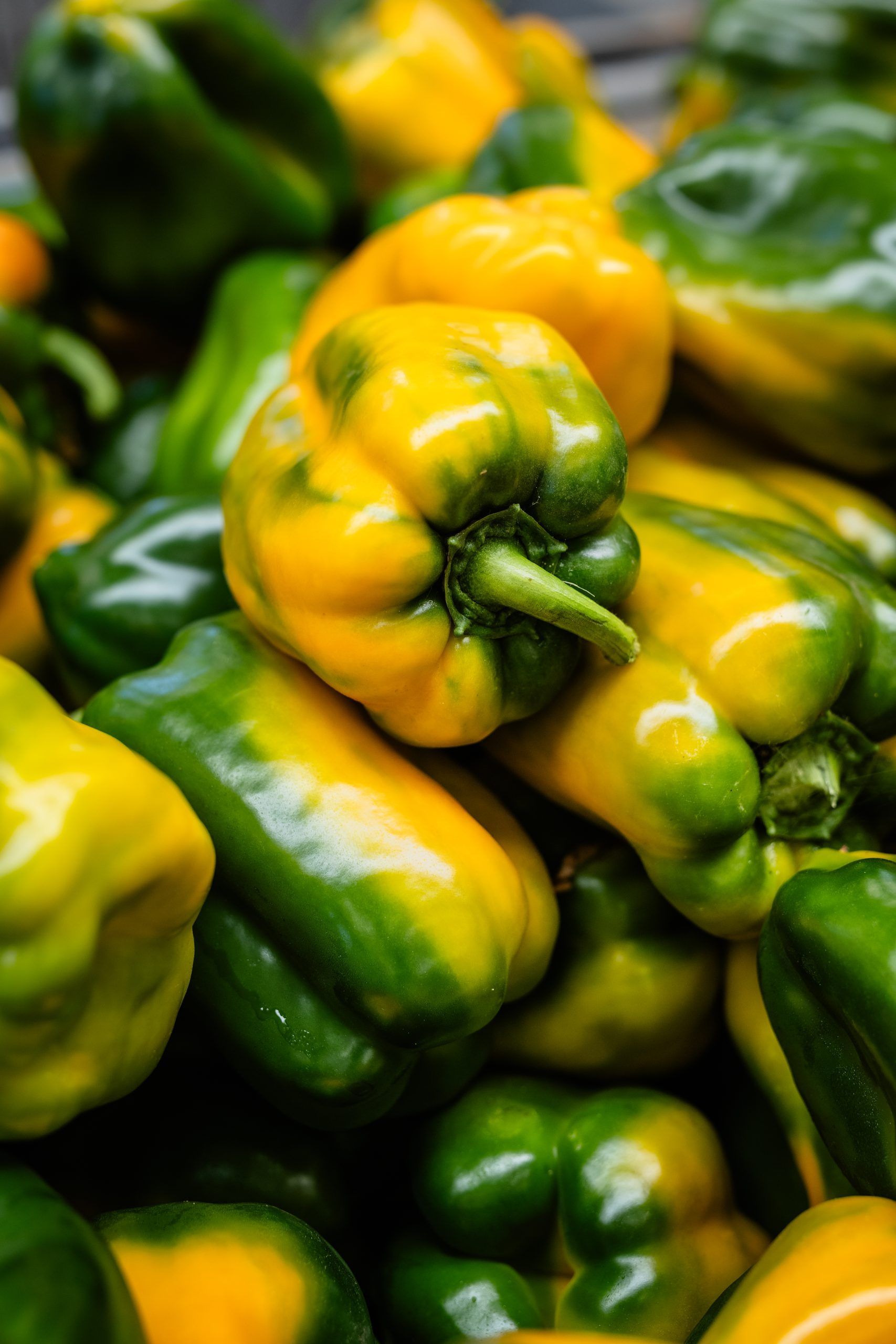 Pila di peperoni verdi e gialli impilati uno sull'altro