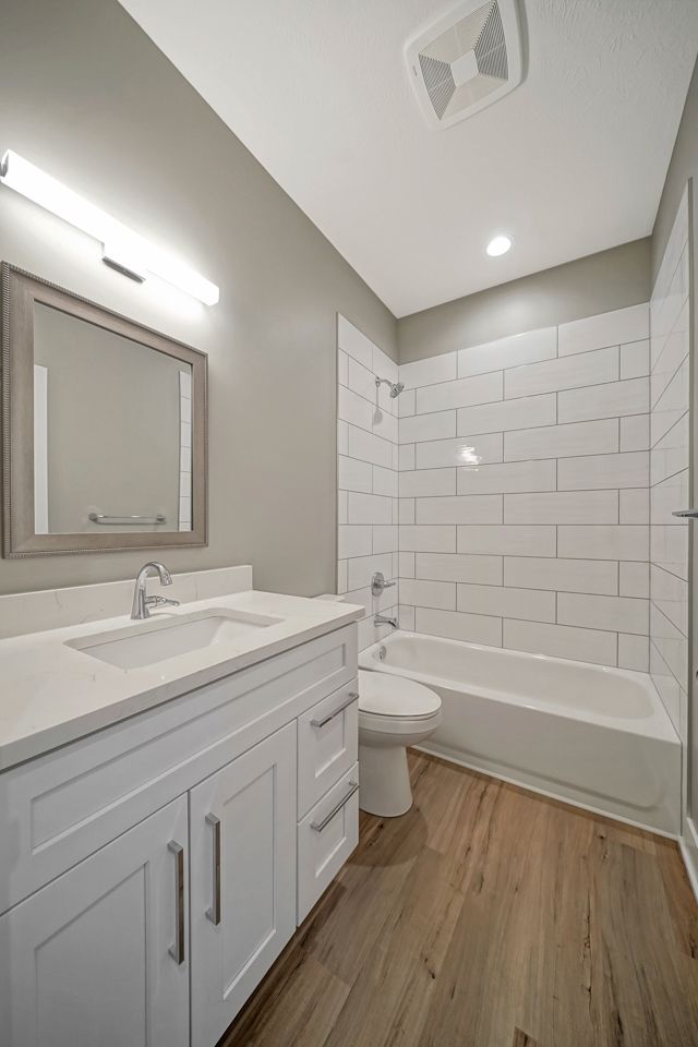 A bathroom with a sink , toilet , tub and mirror.