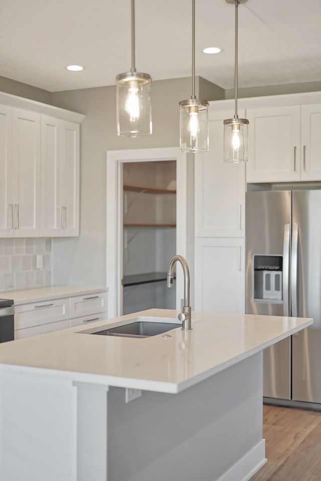 A kitchen with white cabinets and stainless steel appliances