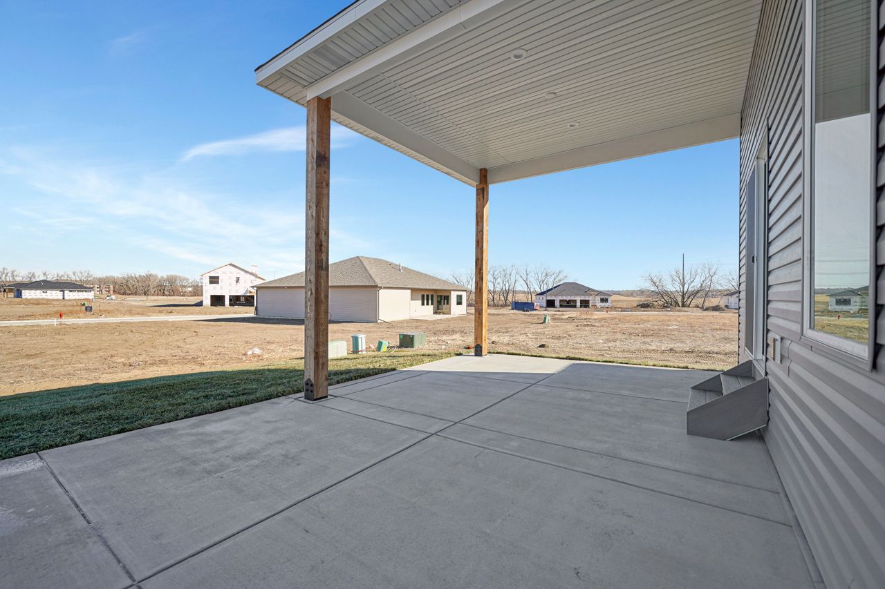 There is a covered patio in front of a house.