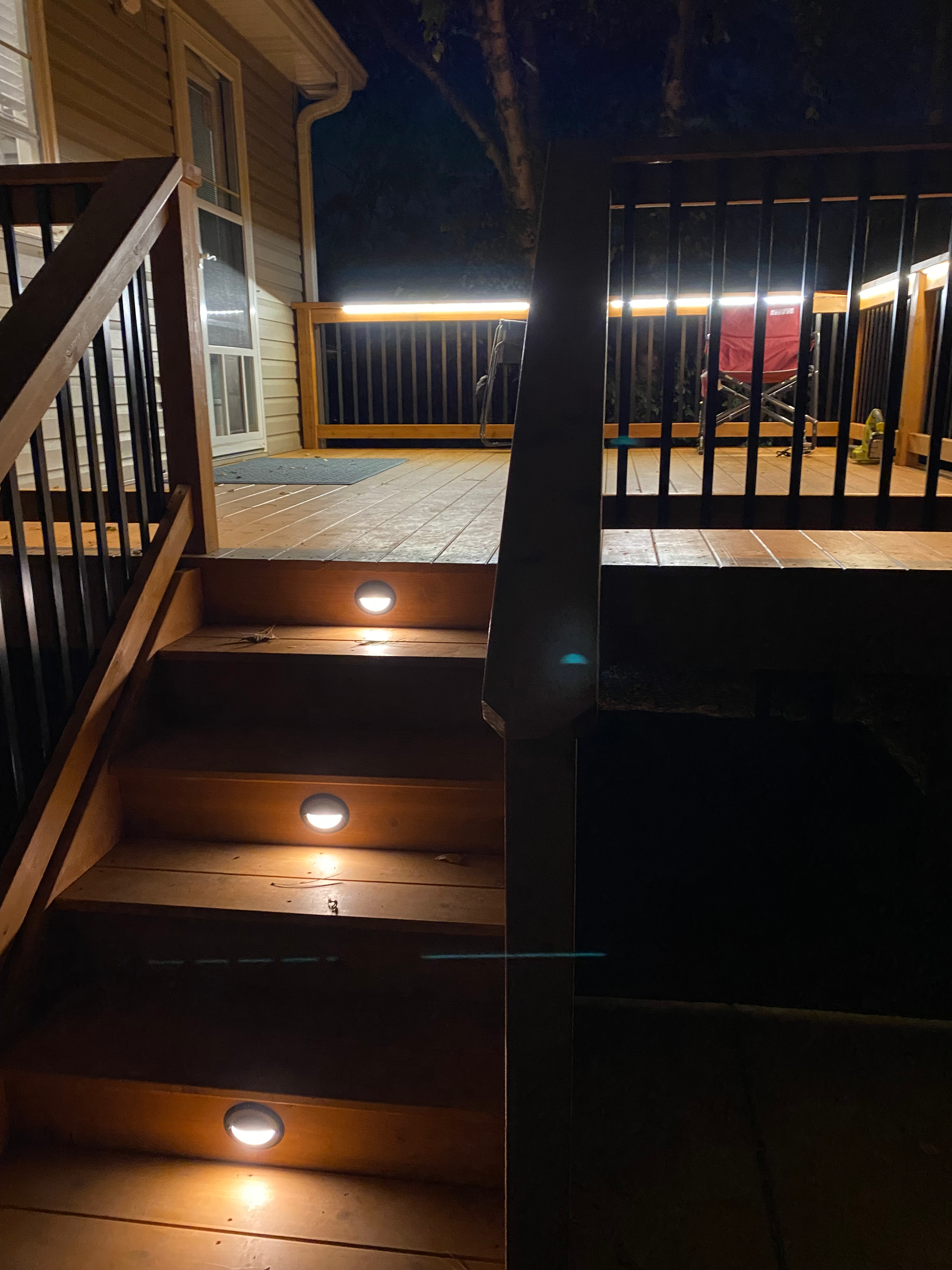 The stairs to the deck are lit up at night.