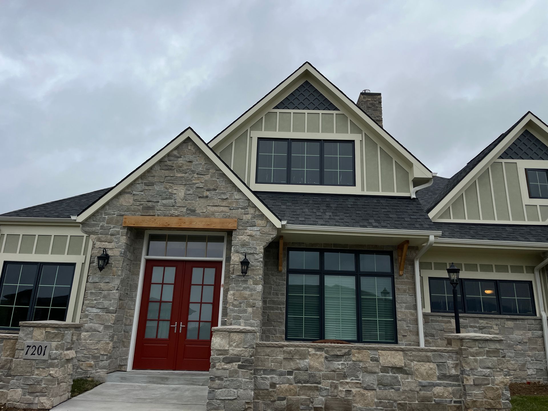 A large house with a lot of windows and a red door.