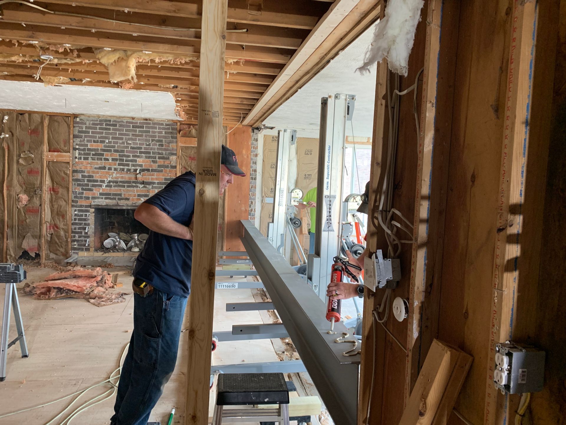 A man installs a beam during a home renovation.