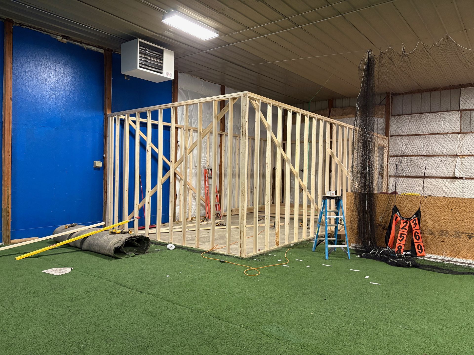 A room with a blue door and a ladder in it is being built.