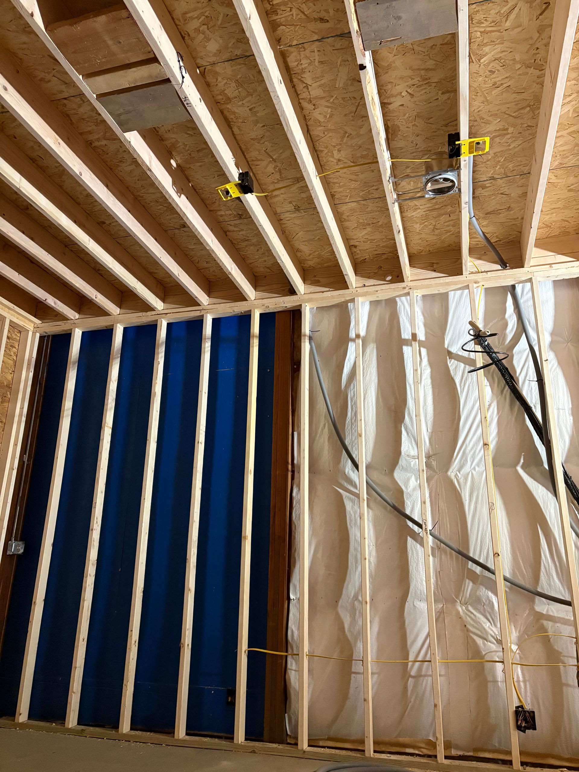The inside of a building under construction with a blue curtain on the wall.
