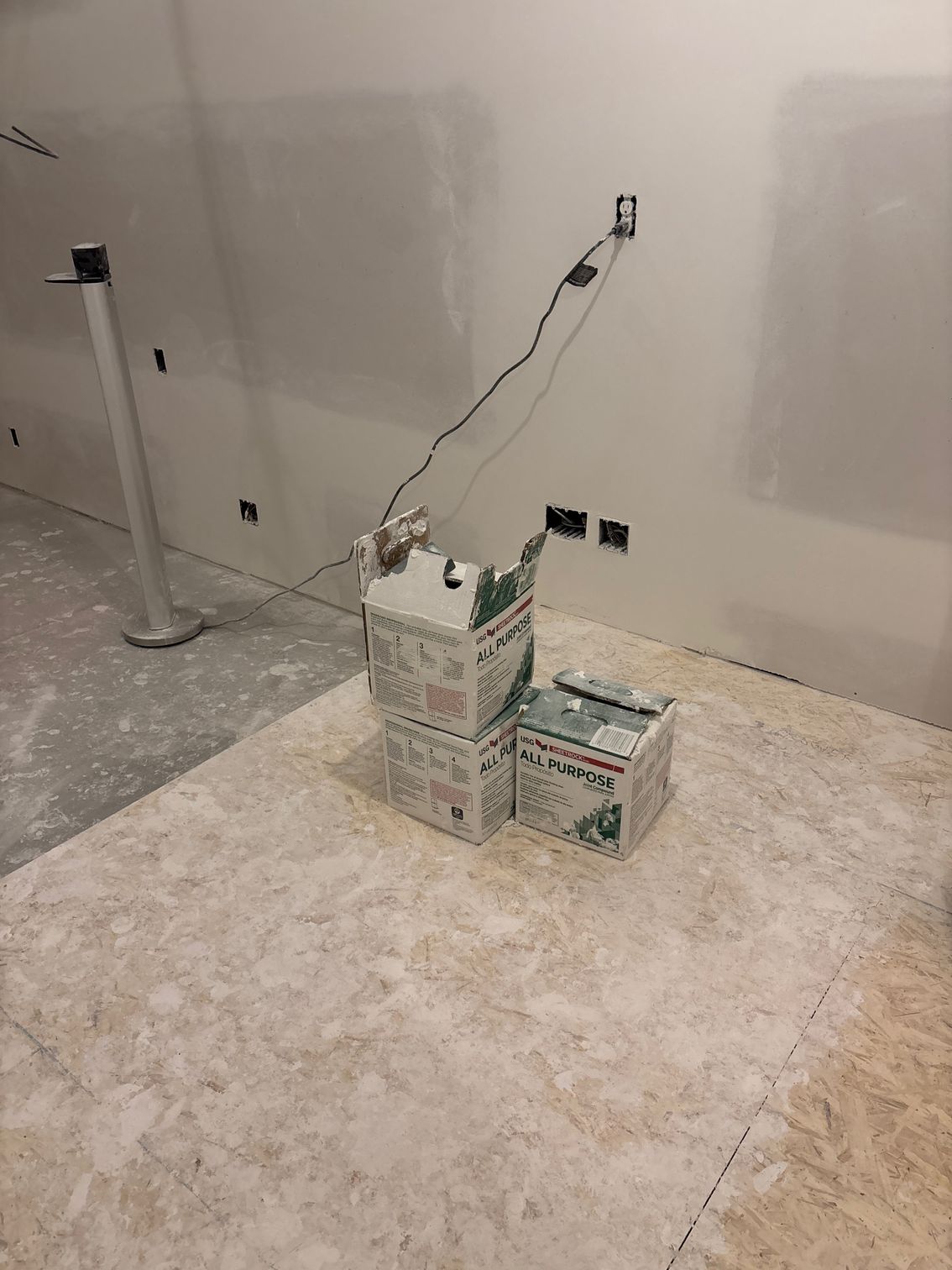 Two boxes of paint are stacked on top of each other in a room.