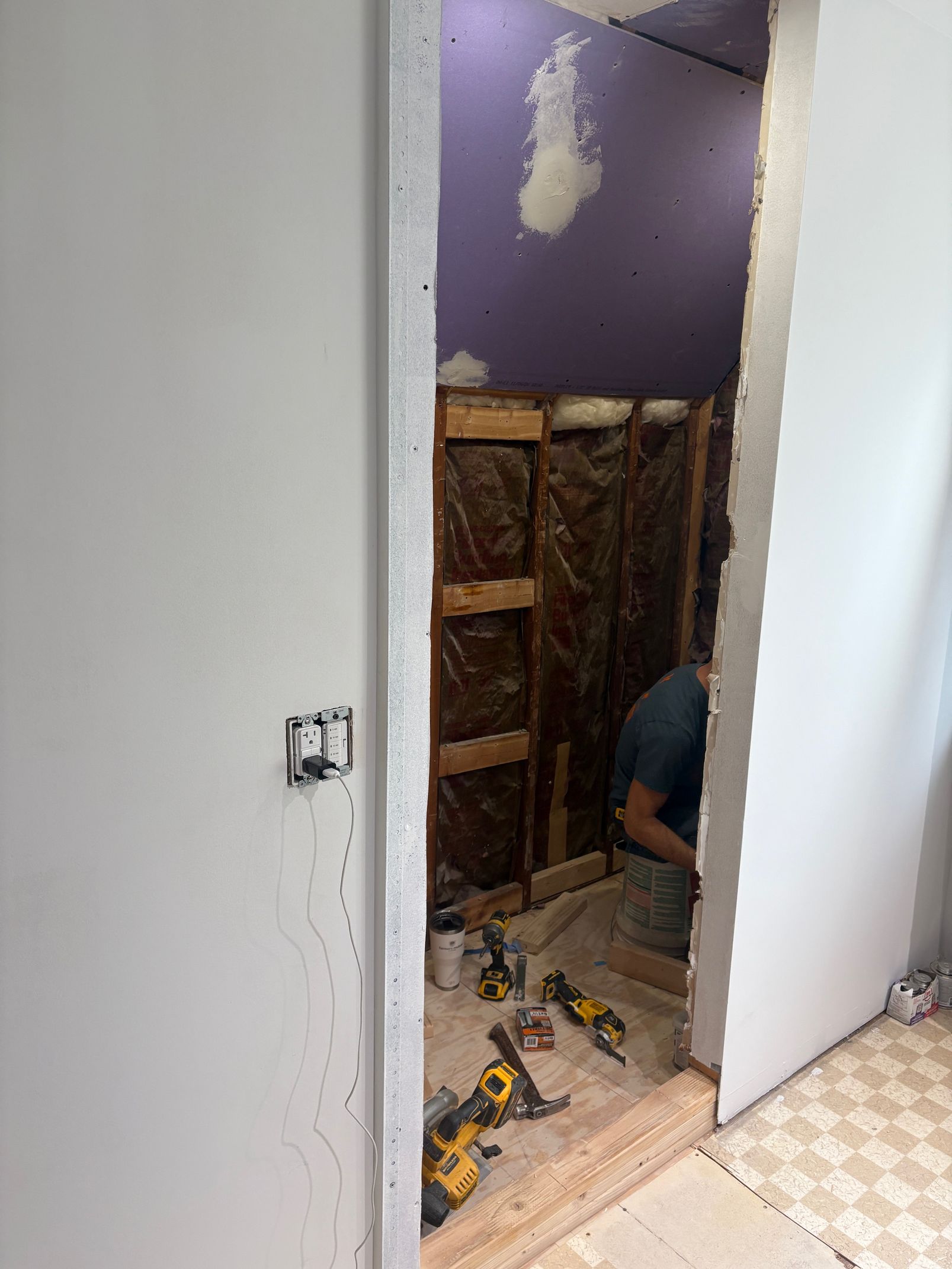 A man is working in a bathroom under construction.