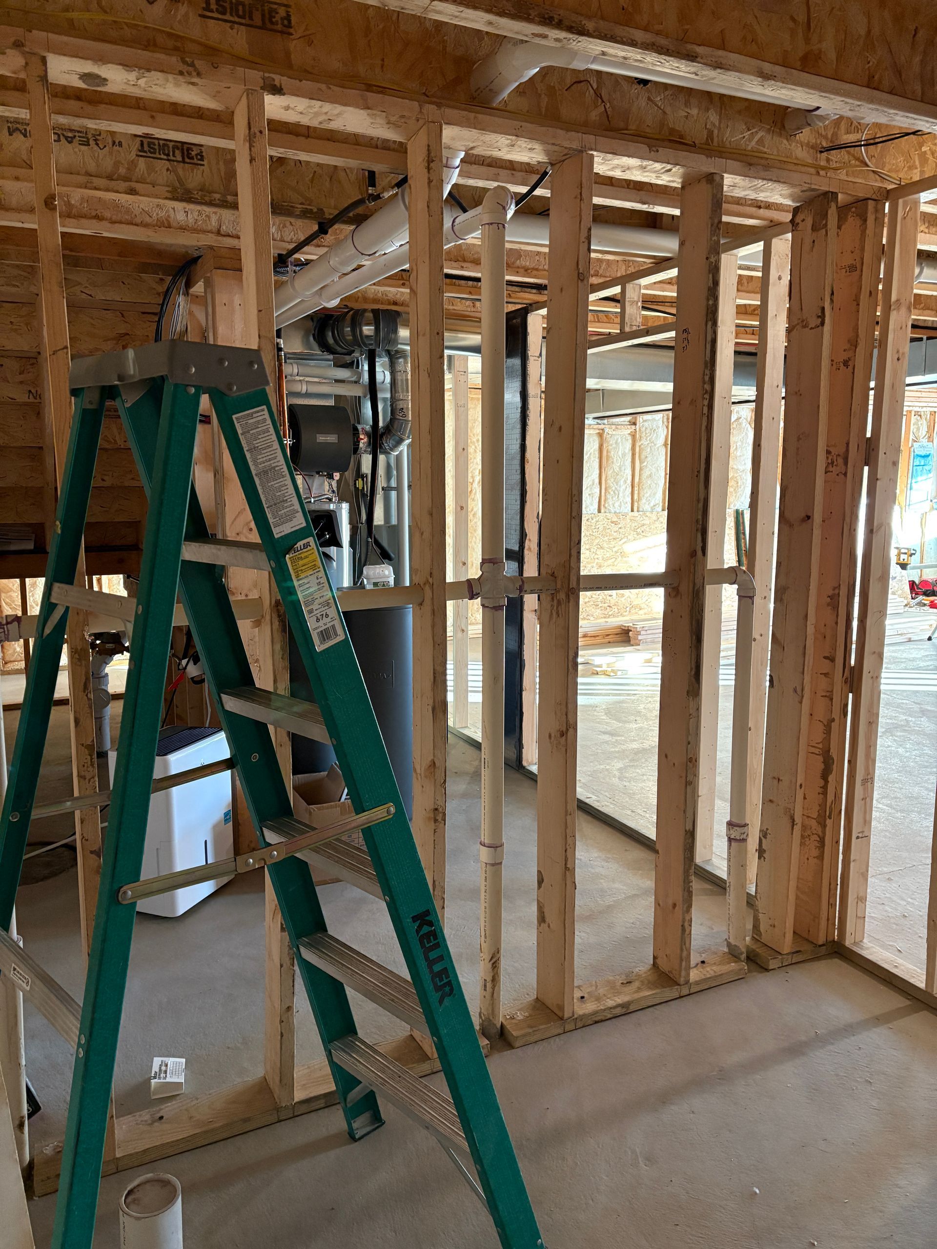 Construction framing with green ladder; interior view.