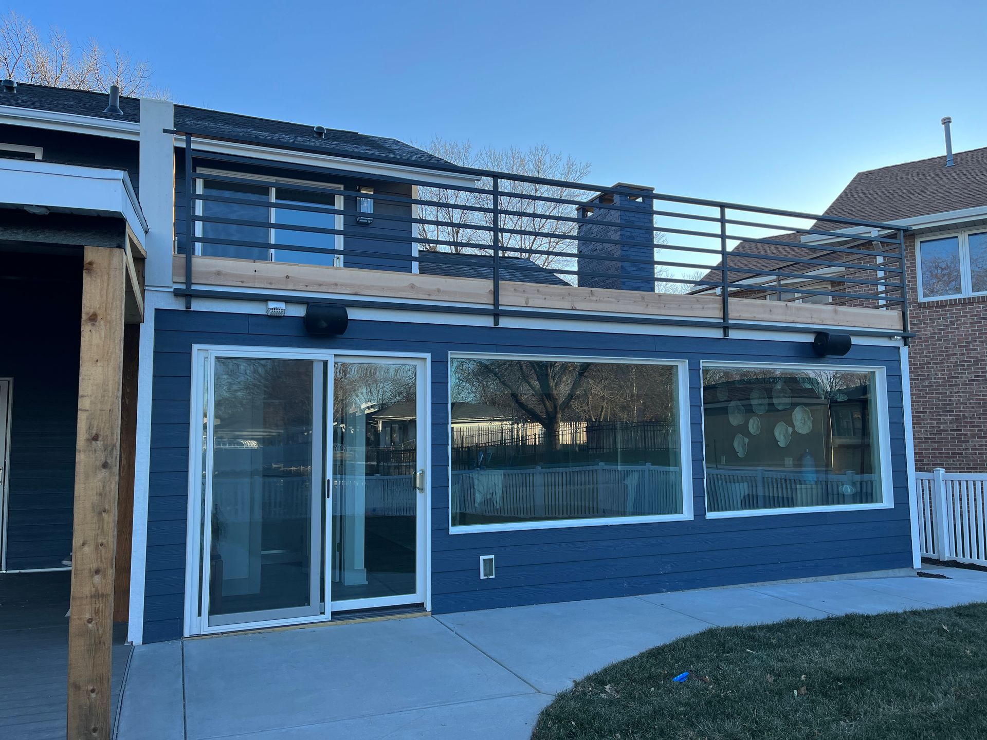 The back of a house with a balcony and sliding glass doors.