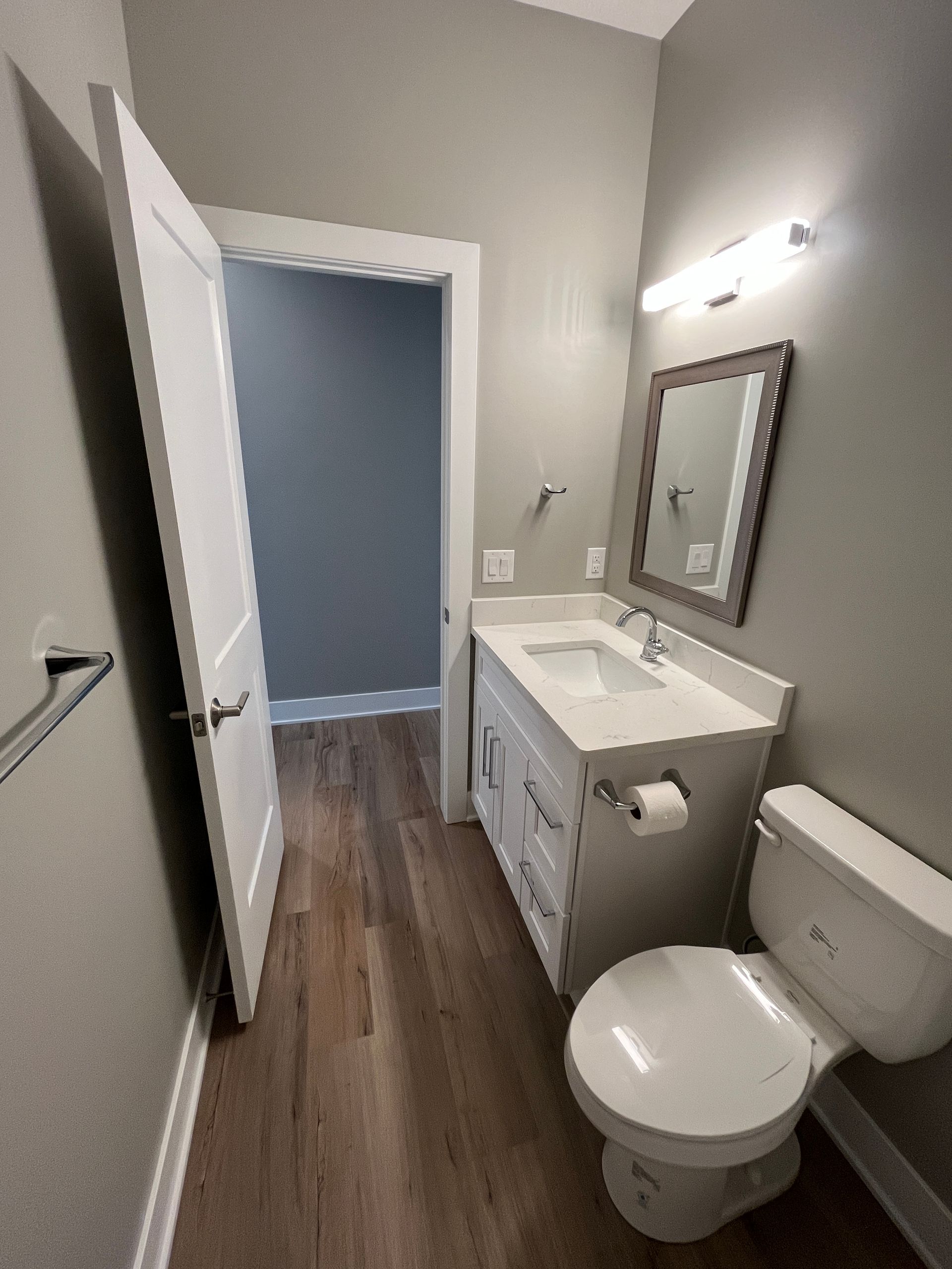 A bathroom with a toilet , sink and mirror