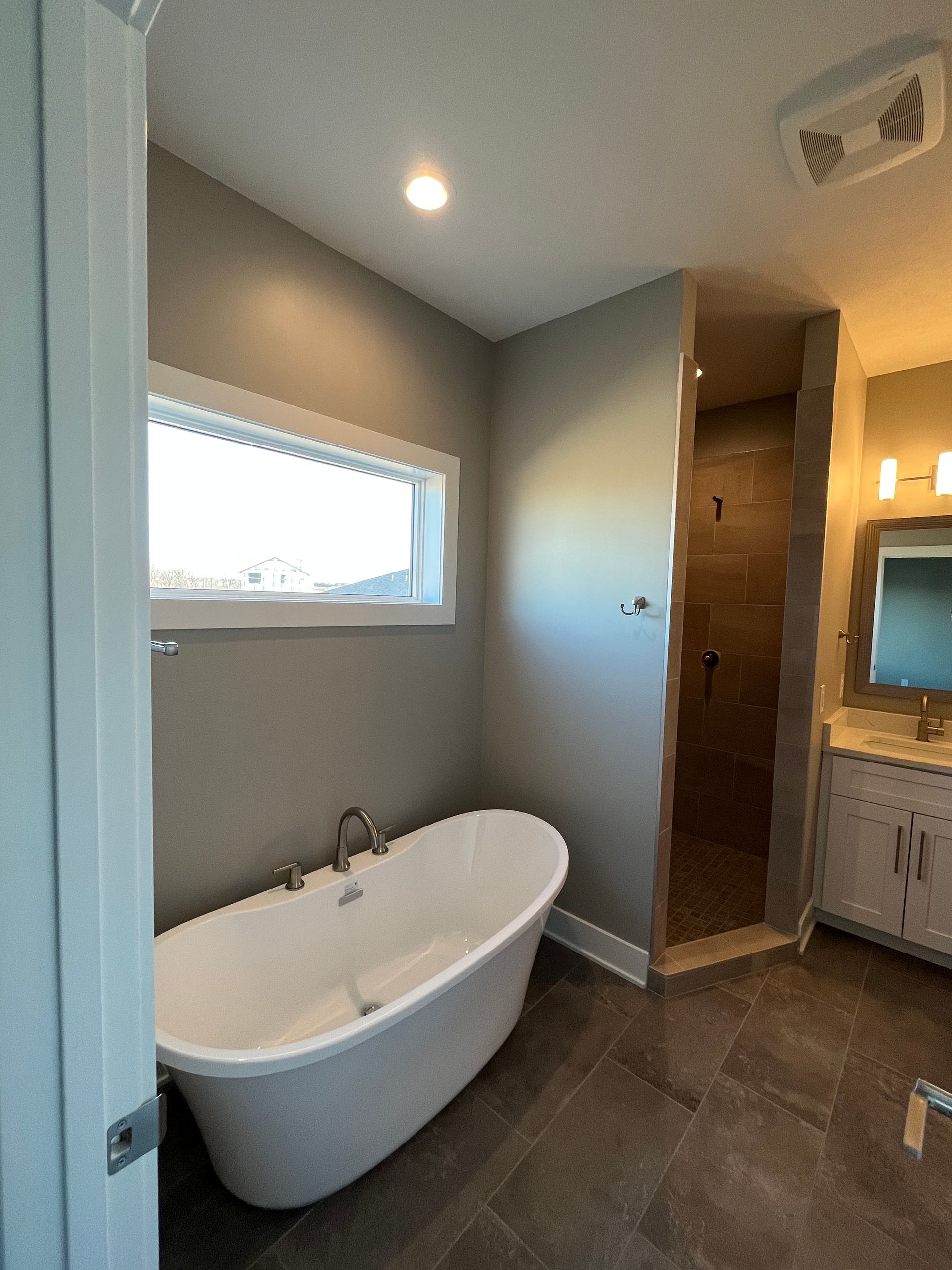 A bathroom with a bathtub and a window