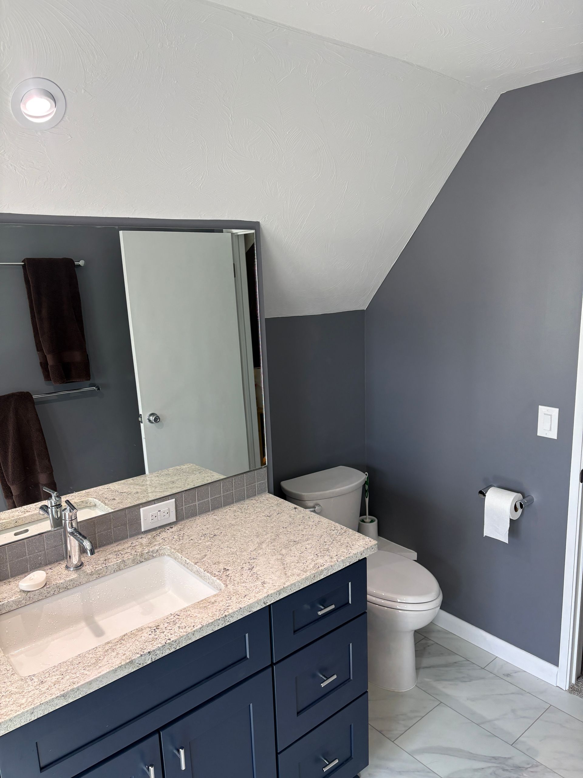 A bathroom with a sink , toilet , and mirror.