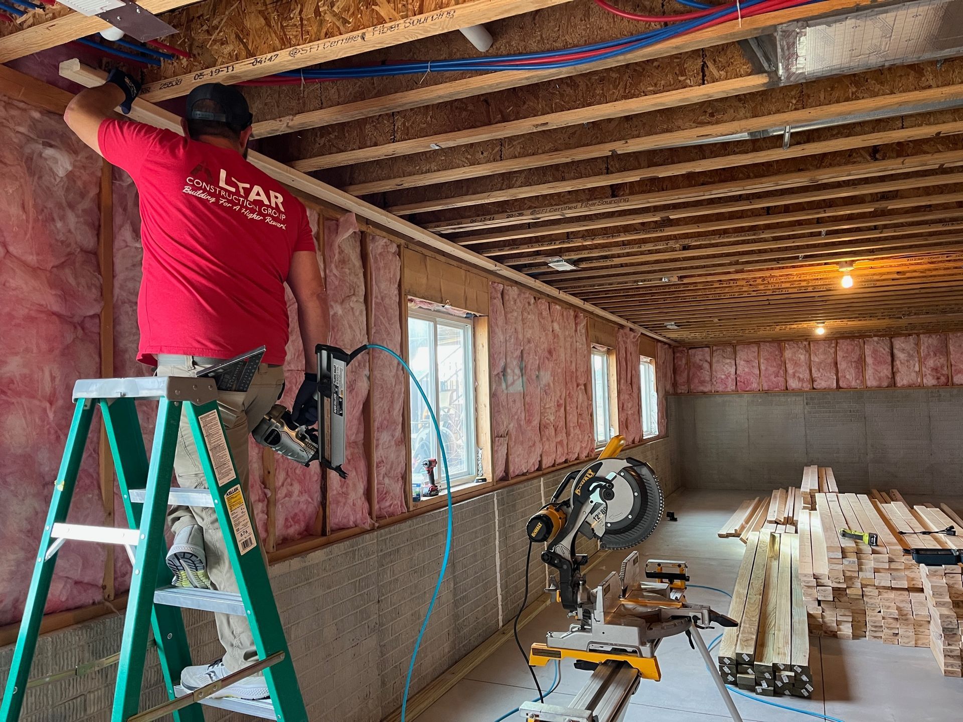 A man is standing on a ladder in a room.
