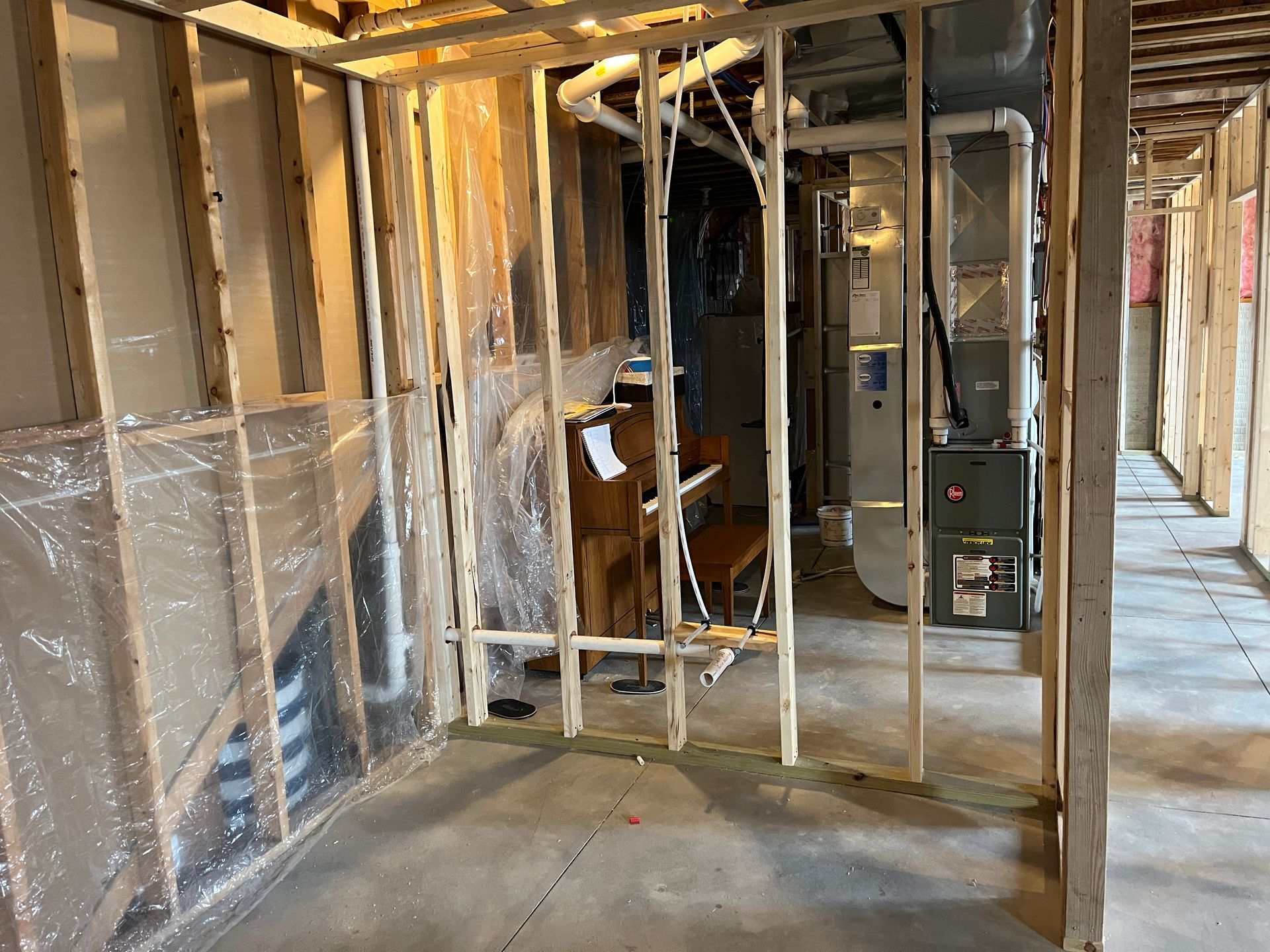 A basement under construction with a furnace and a wooden frame.