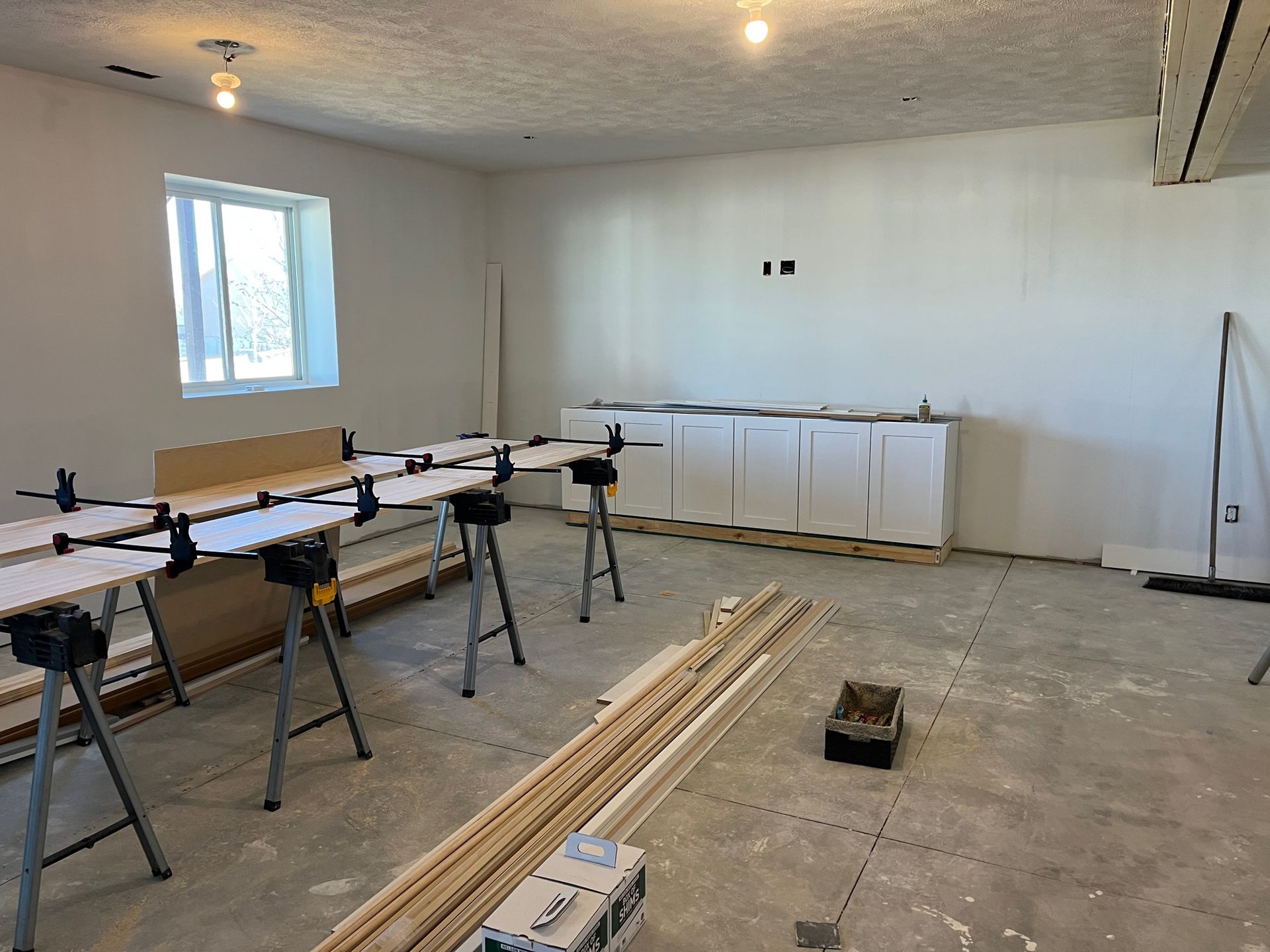 A room with a lot of wooden tables and a window.