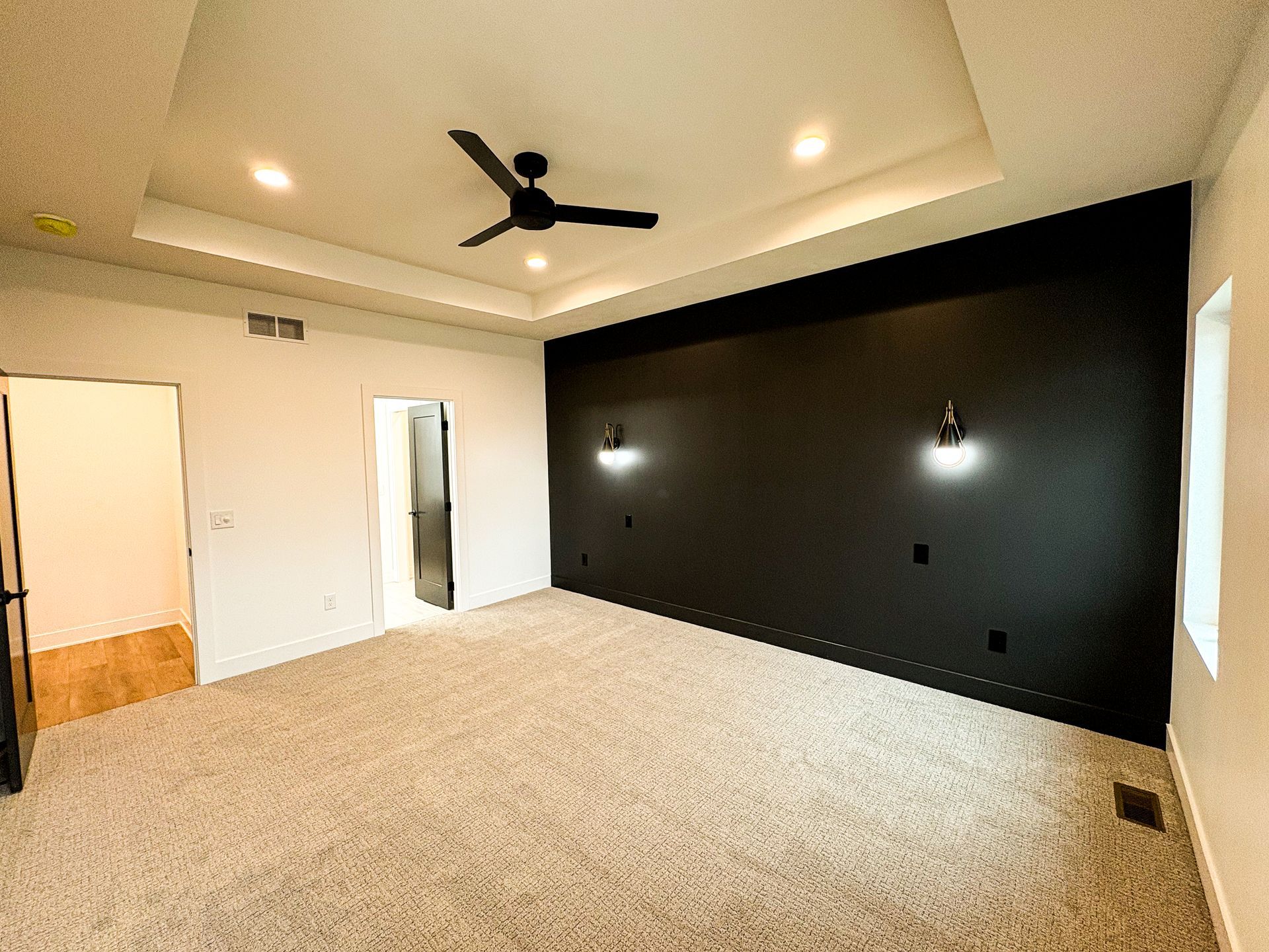 A mudroom bench with two dark wood drawers, a vertical maple slat wall with coat hooks and open cubby shelves above, beside a dark door.