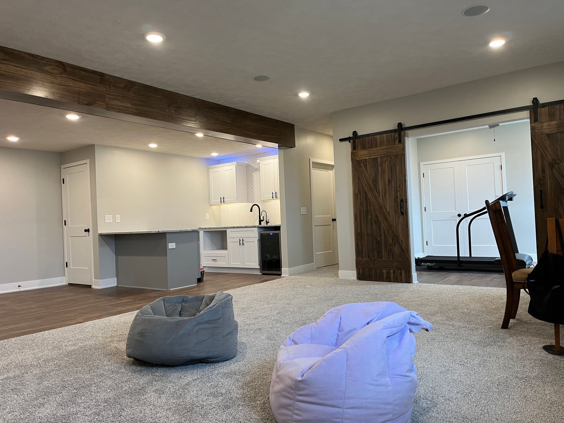 A living room with two bean bag chairs and a treadmill.