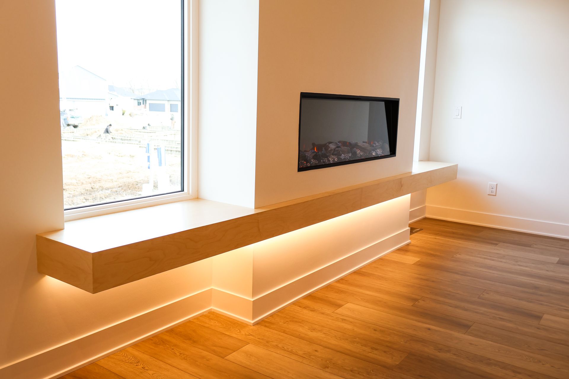 Modern room with a fireplace and built-in bench. Beige wood and white walls; ambient lighting.