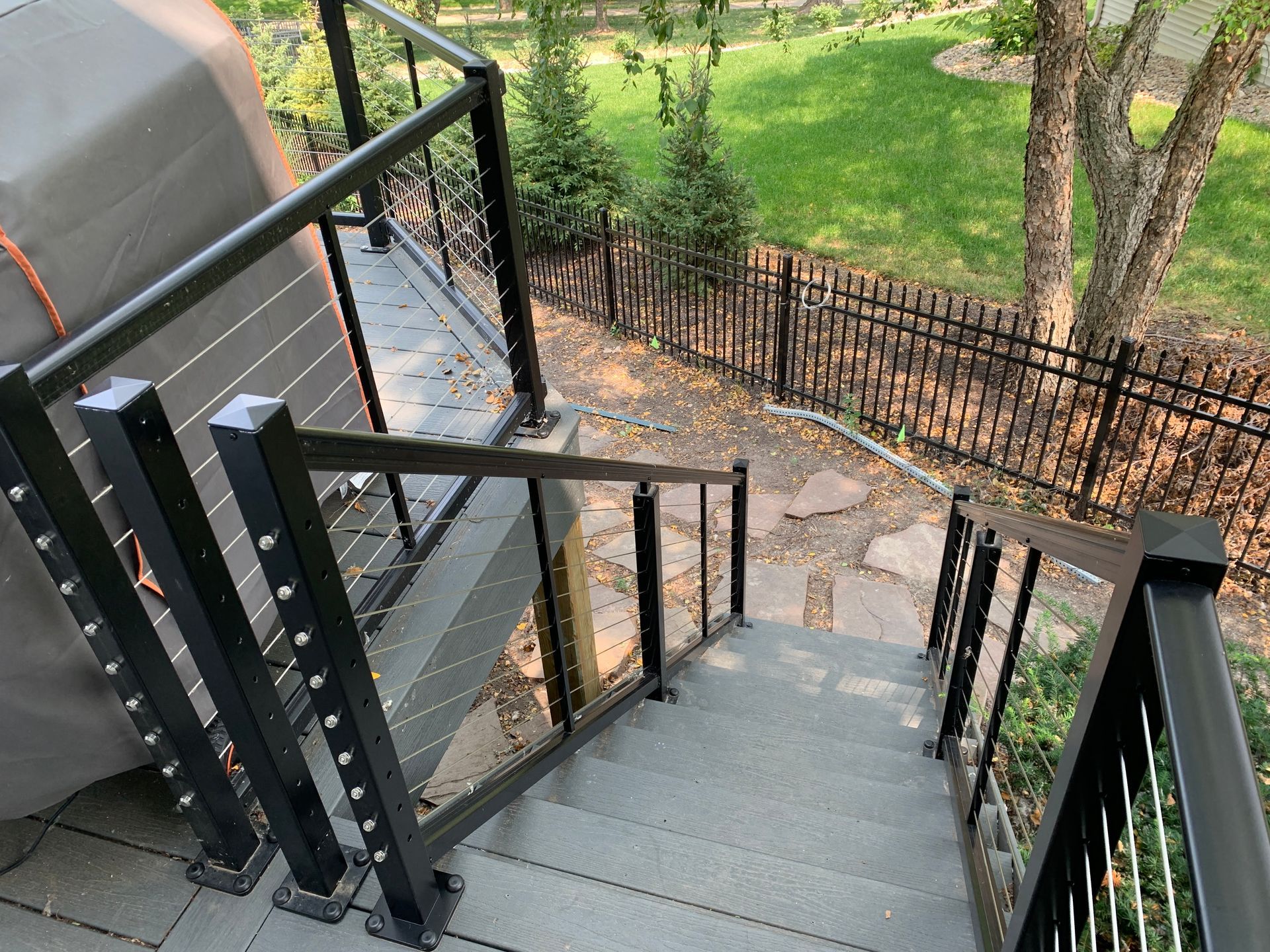 A set of stairs leading up to a deck with a fence in the background.