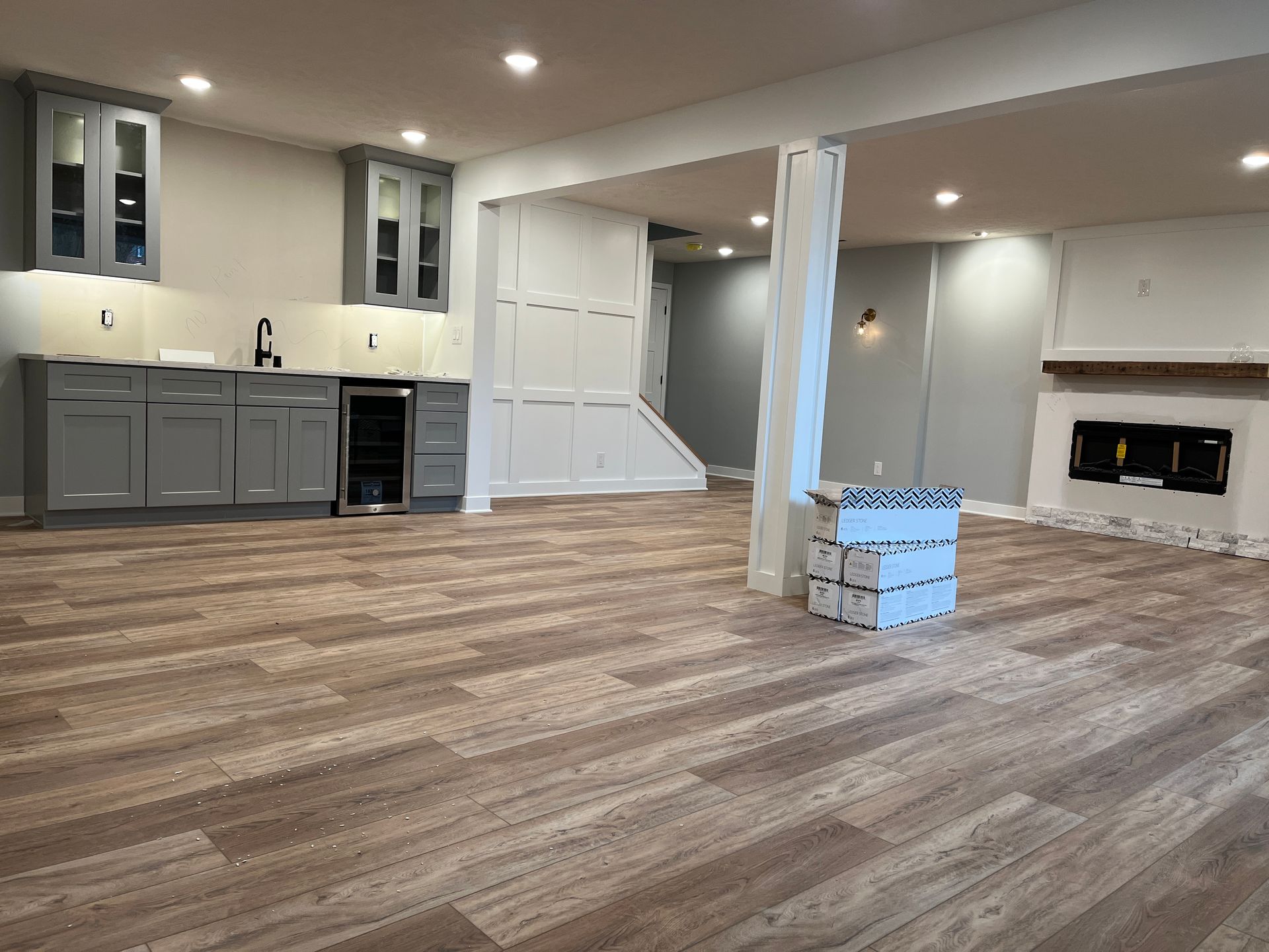 A large empty room with hardwood floors and a fireplace.