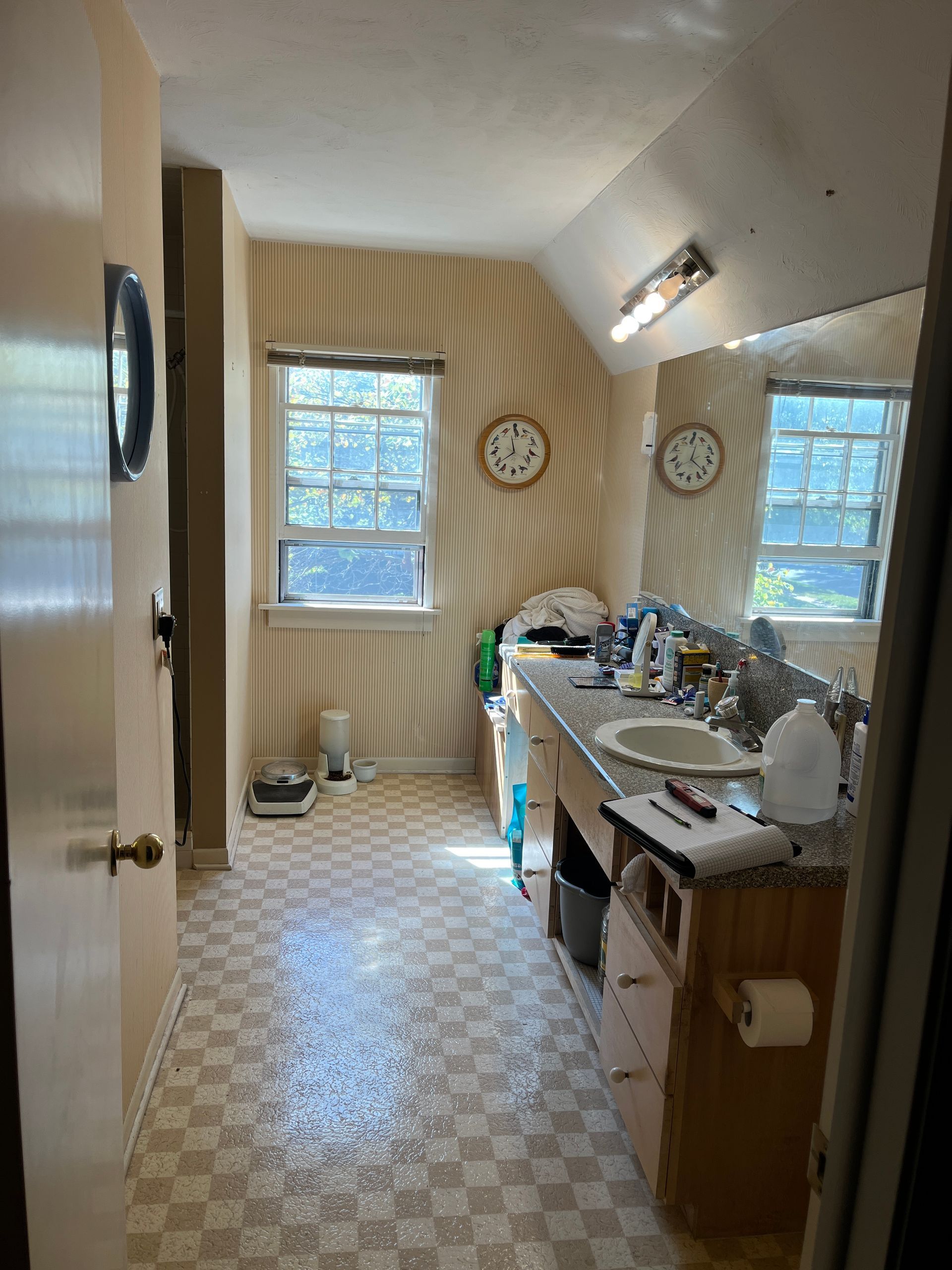 A bathroom with two sinks , a mirror and a scale.