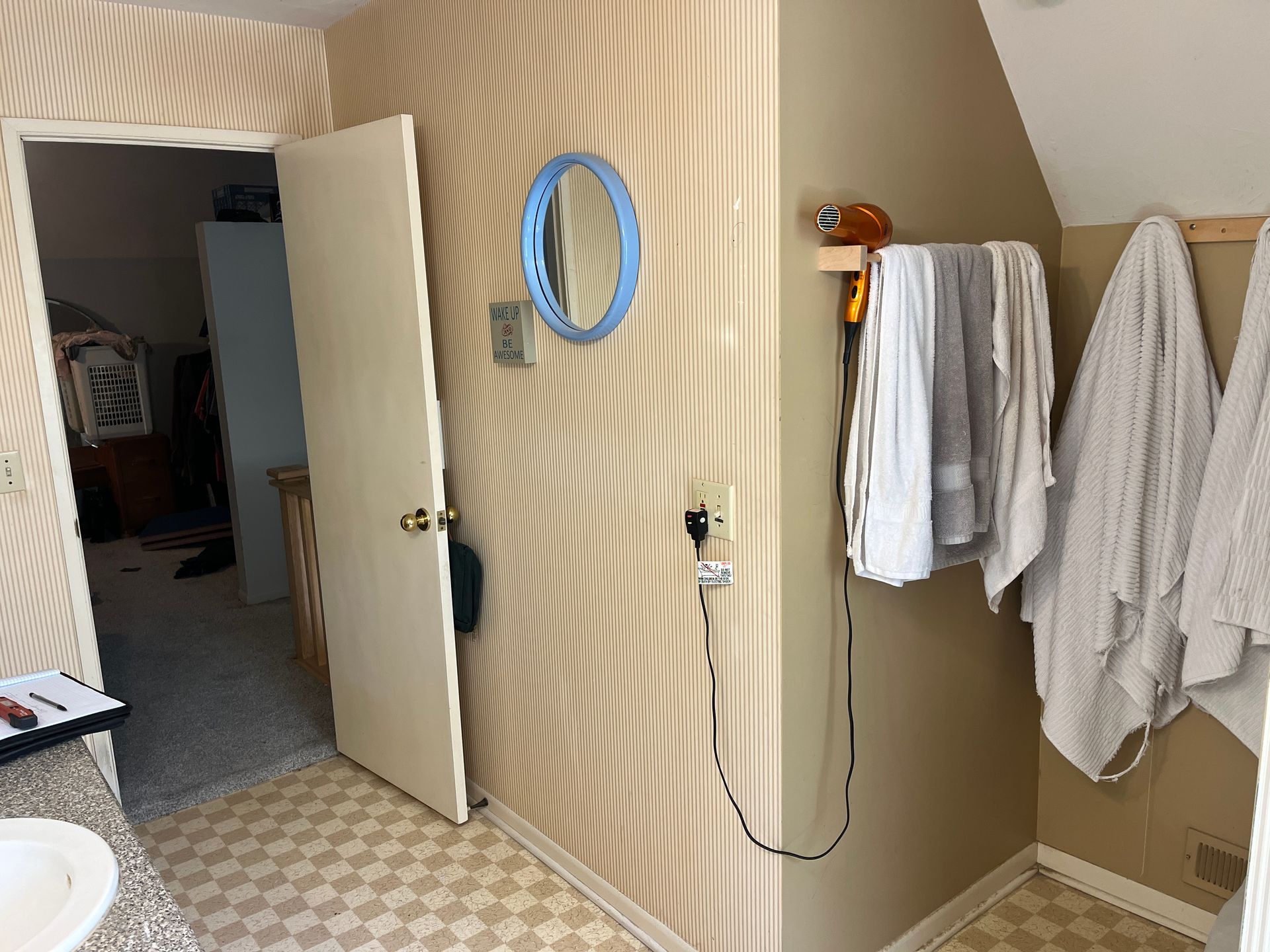 A bathroom with a mirror and towels hanging on the wall