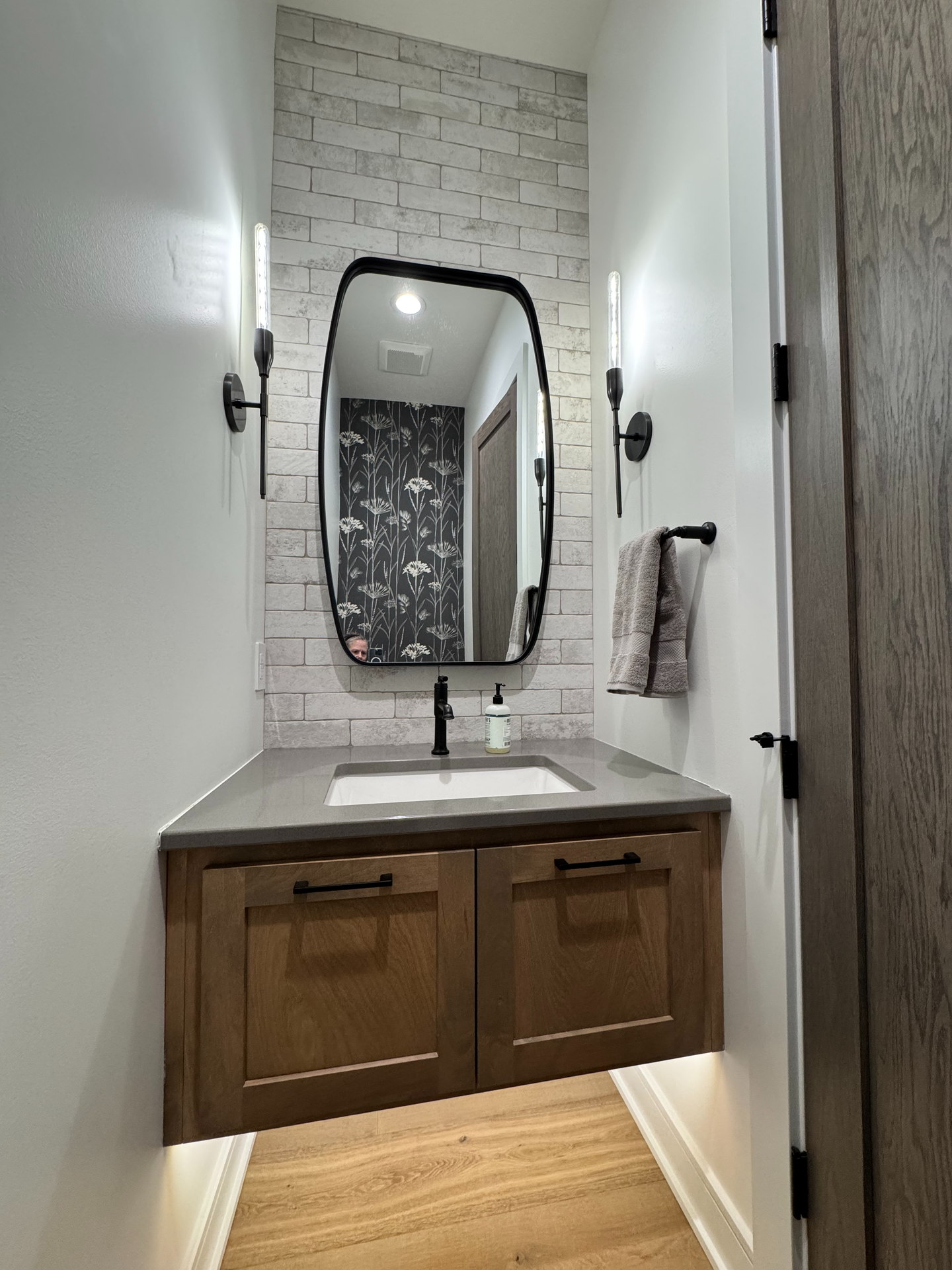 A bathroom with a sink , mirror and cabinets.