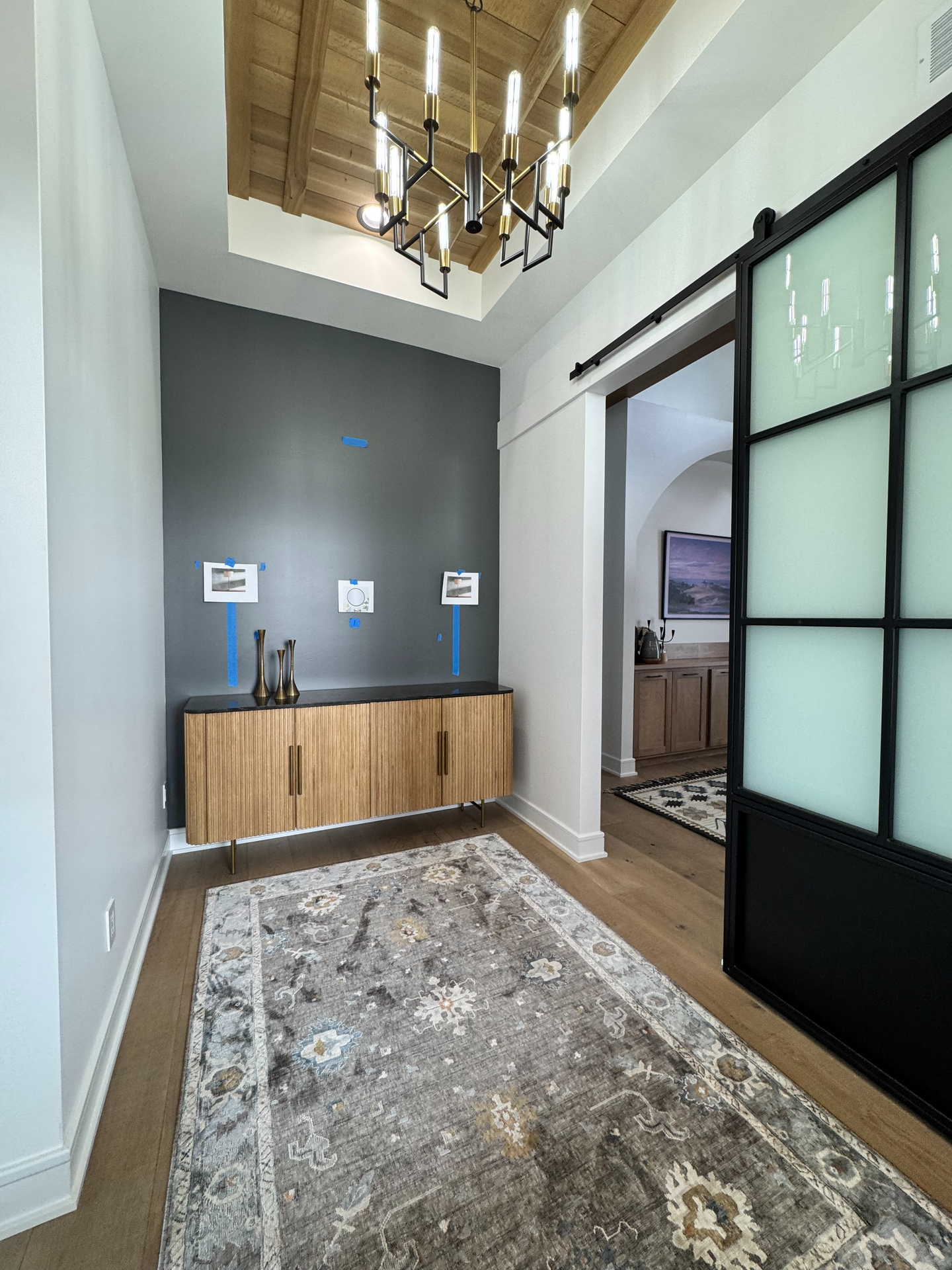 A hallway with a sliding glass door and a wooden cabinet.