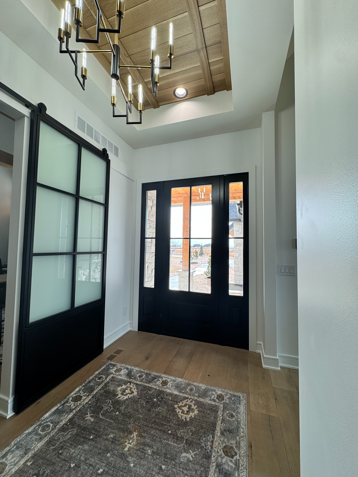 A hallway with a sliding glass door and a rug