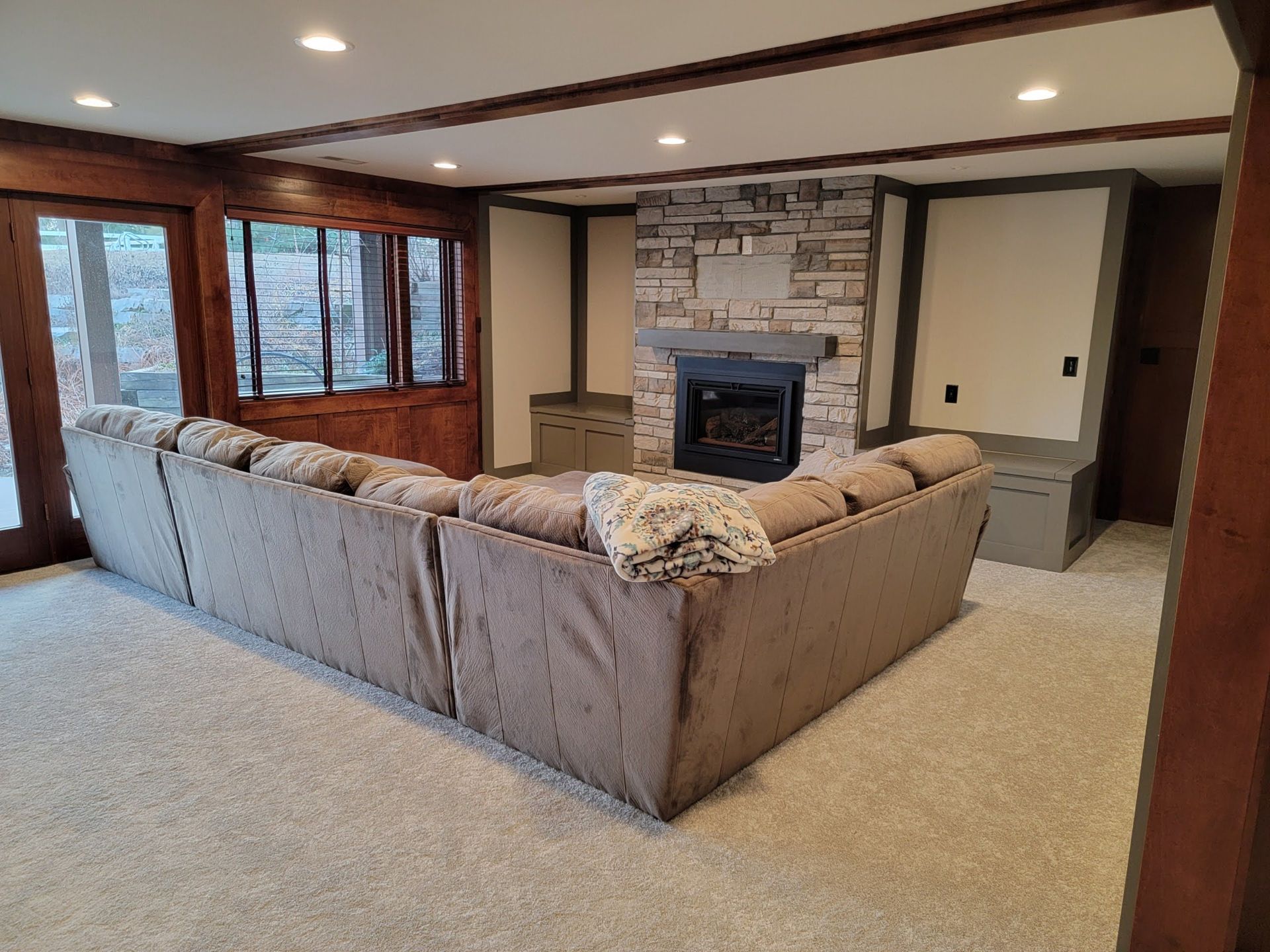 A living room with a large sectional couch and a fireplace.