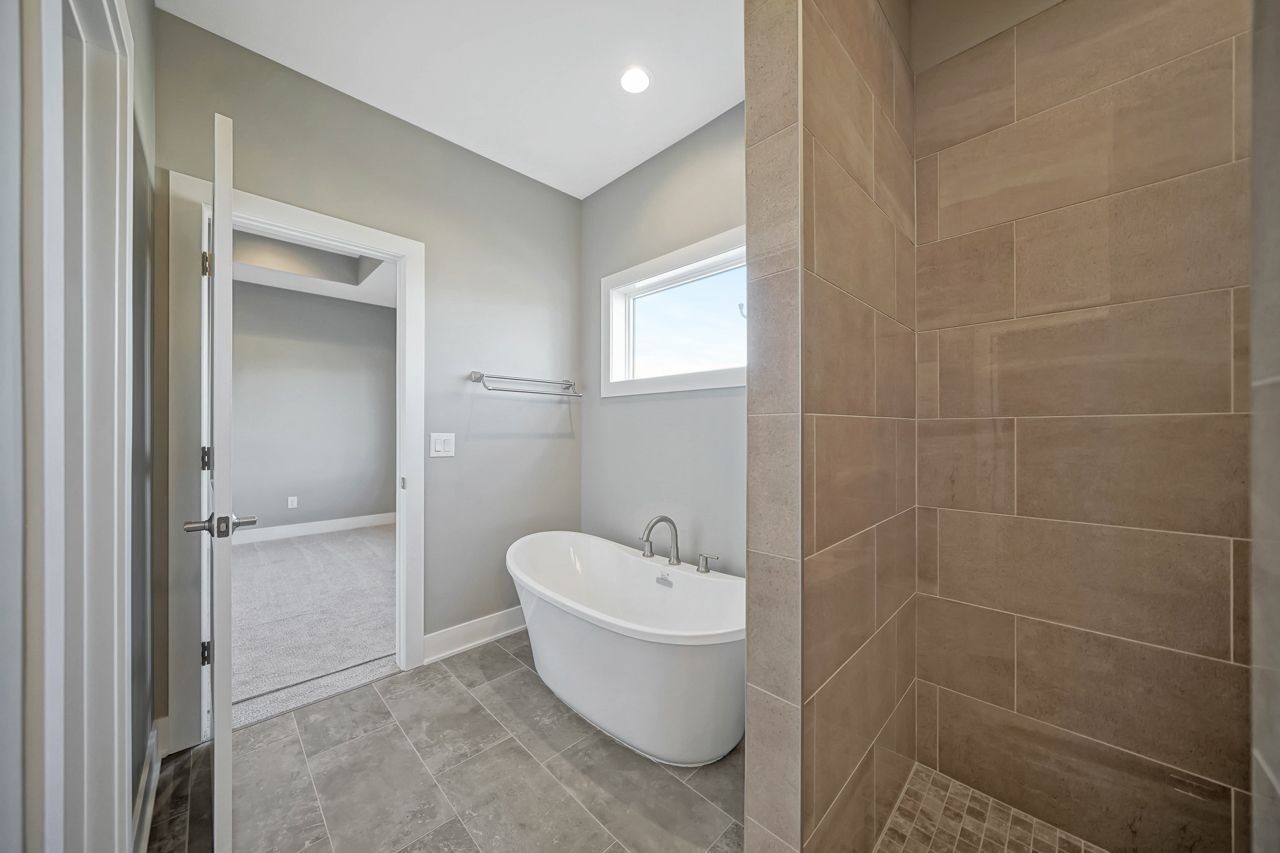 A bathroom with a tub and a walk in shower.
