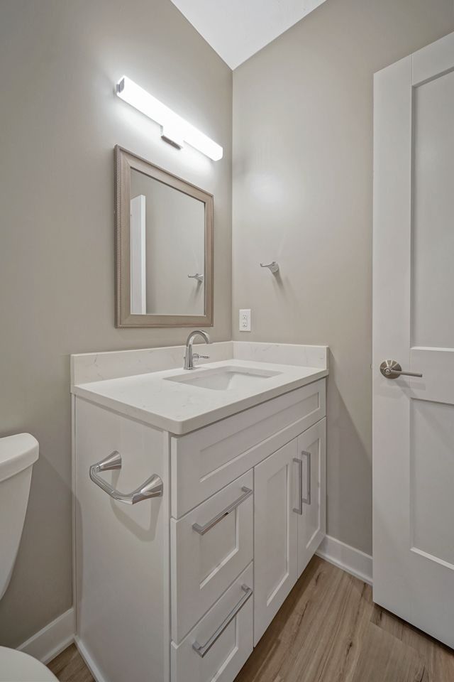 A bathroom with a sink , toilet and mirror.