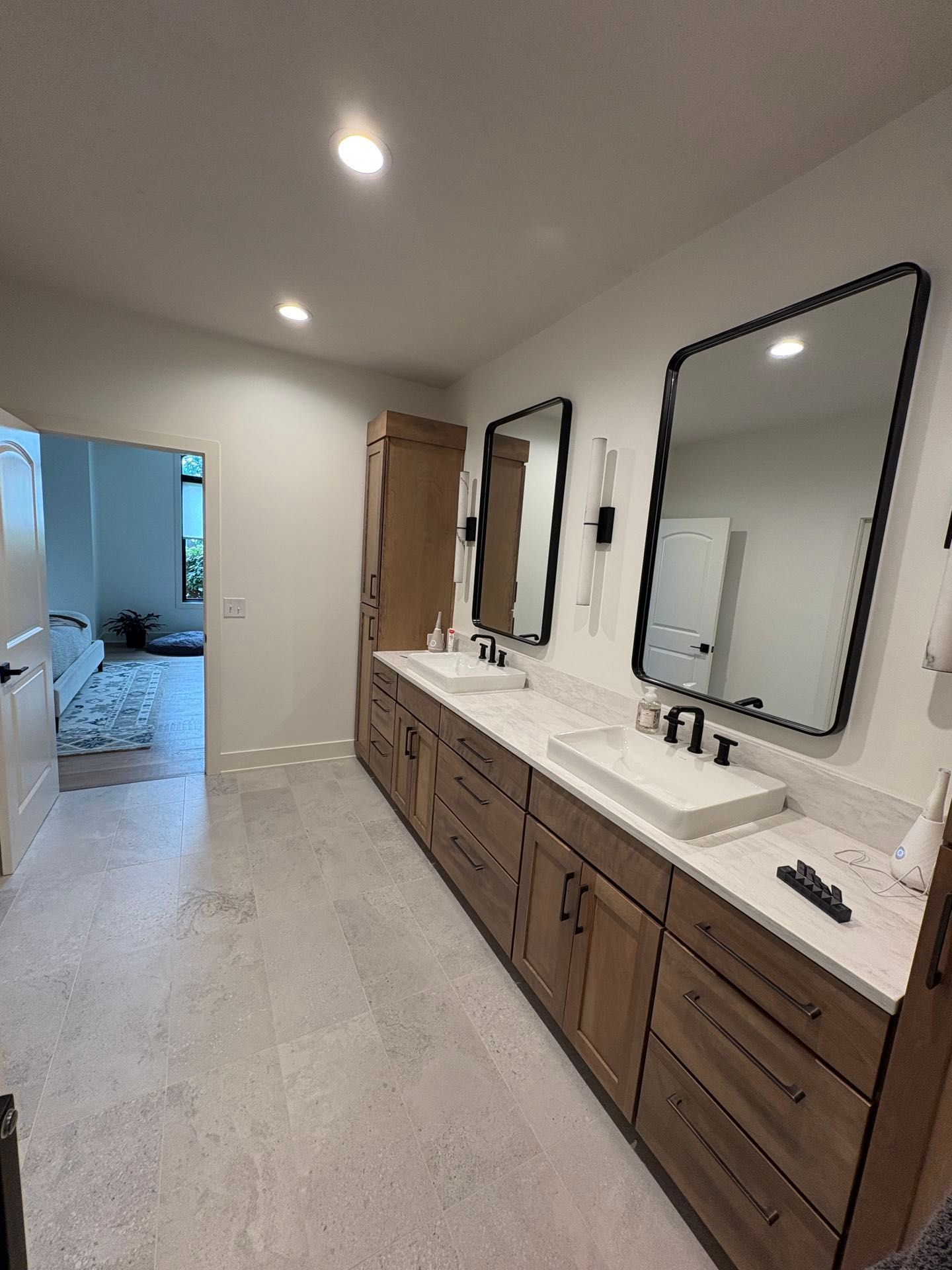 A primary bathroom double vanity with quartz counters, framed mirrors, and black fixtures, Lincoln, NE.