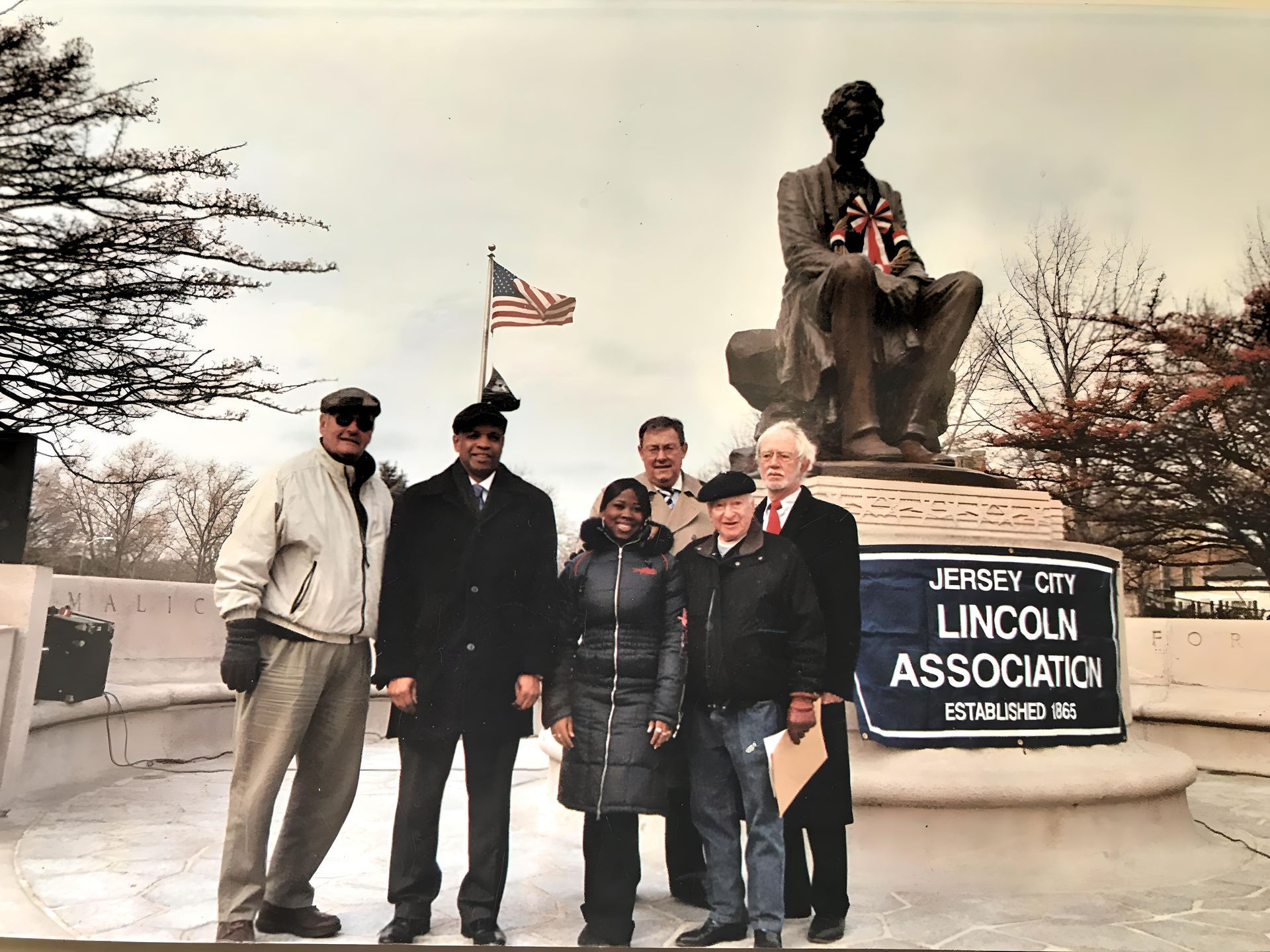 A group of people standing in front of a sign that says lincoln association