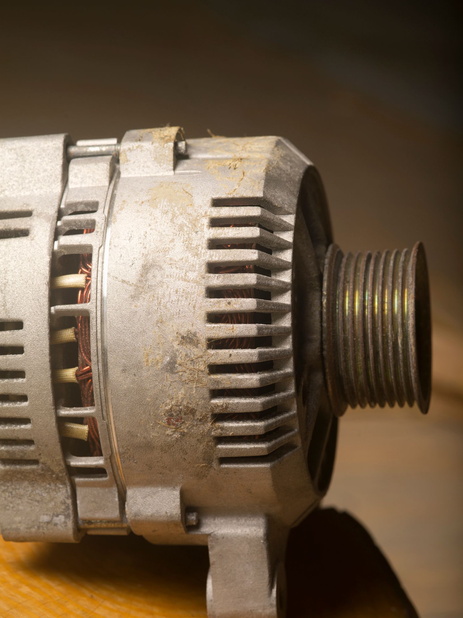 A close up of an alternator on a wooden table
