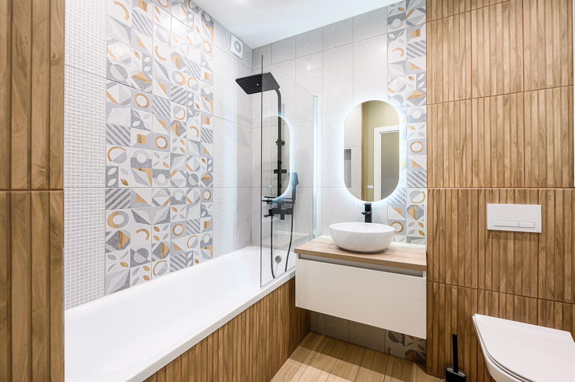 Modern bathroom with wood-look tile, patterned accents, a white bathtub, floating vanity with sink, and a round mirror.