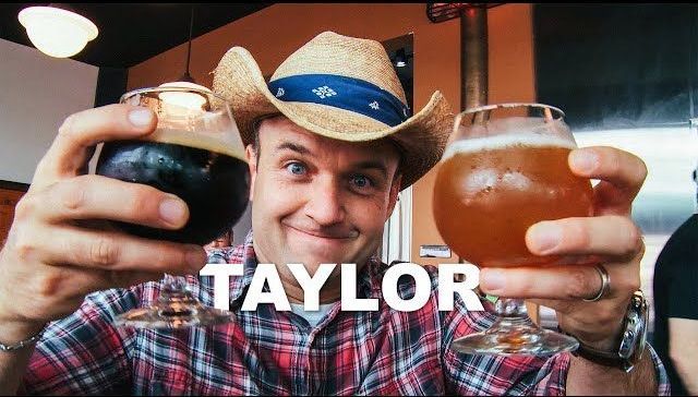 a man in a cowboy hat is holding two glasses of beer .
