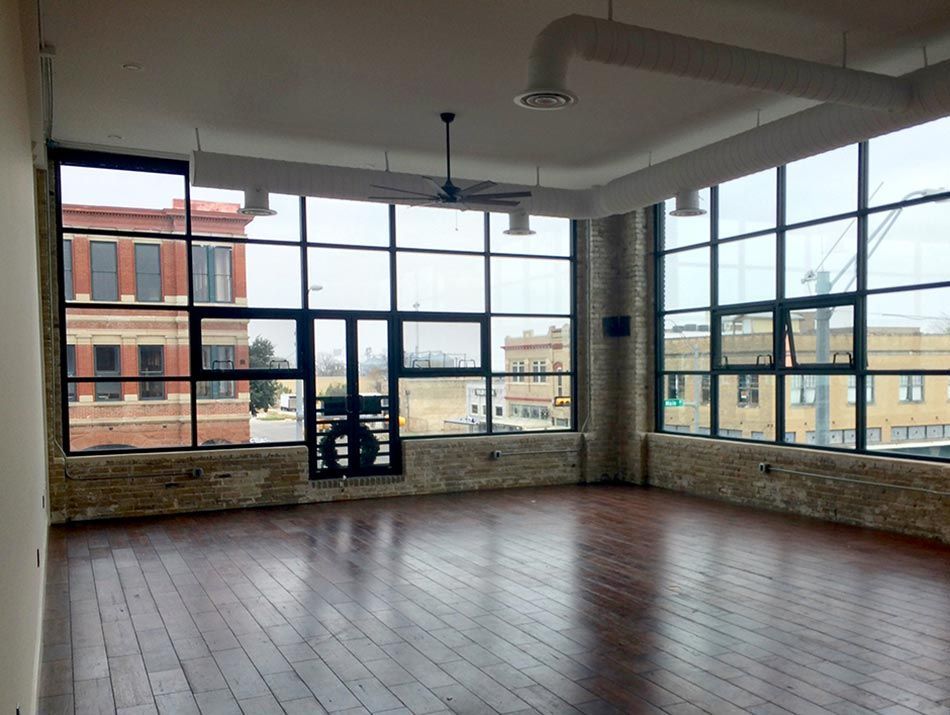 an empty room with a lot of windows and a wooden floor