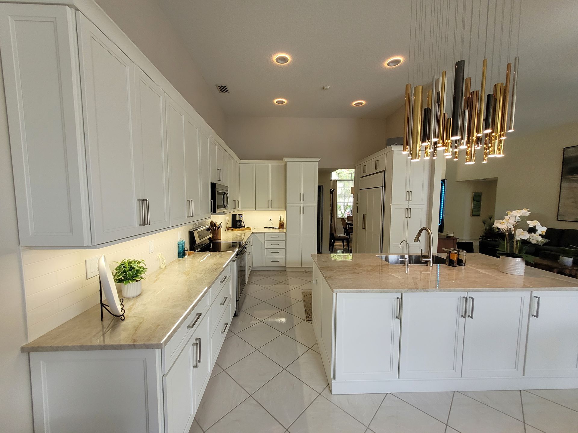 Bright modern white kitchen with island, pendant lights, and quartz countertops