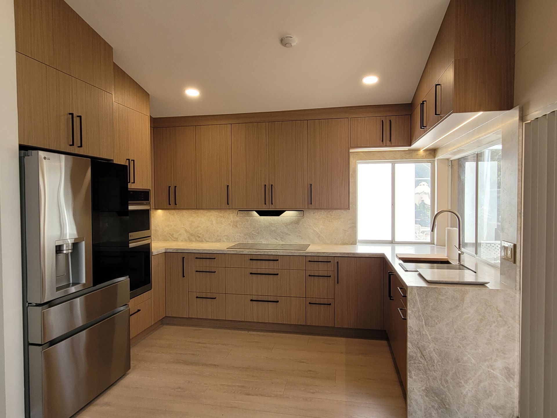Modern kitchen with wood cabinets, stainless steel appliances, and granite countertops