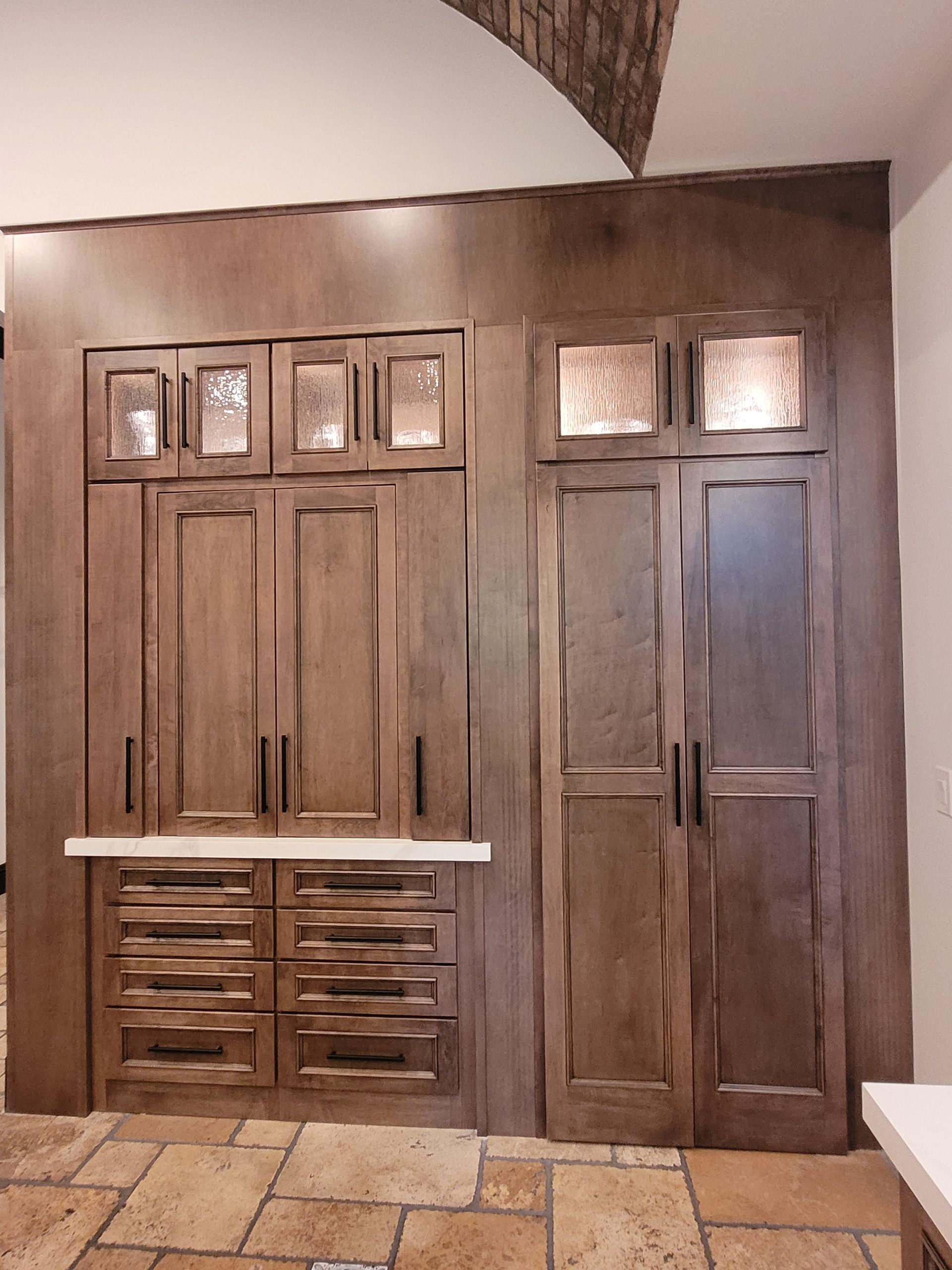 Wooden closet doors with small windows in a rustic interior wall.
