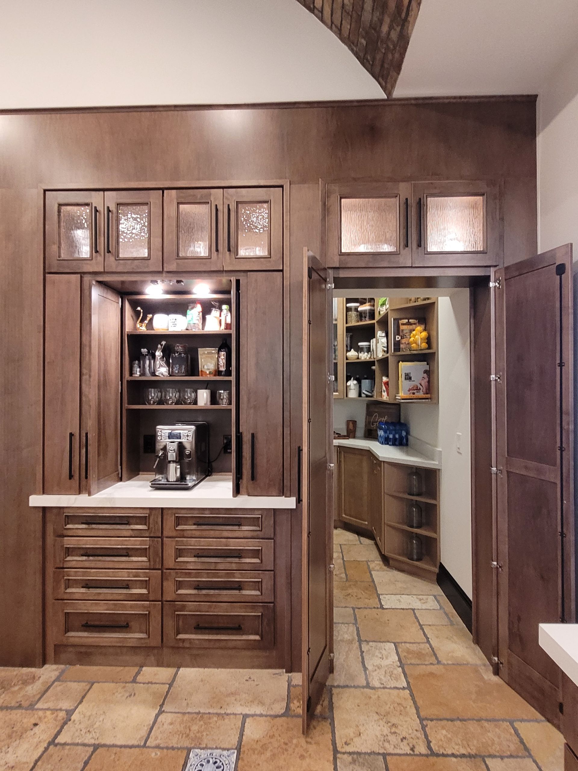 Wood-paneled home bar with sink, cabinets, and open doorway to a pantry or kitchen area