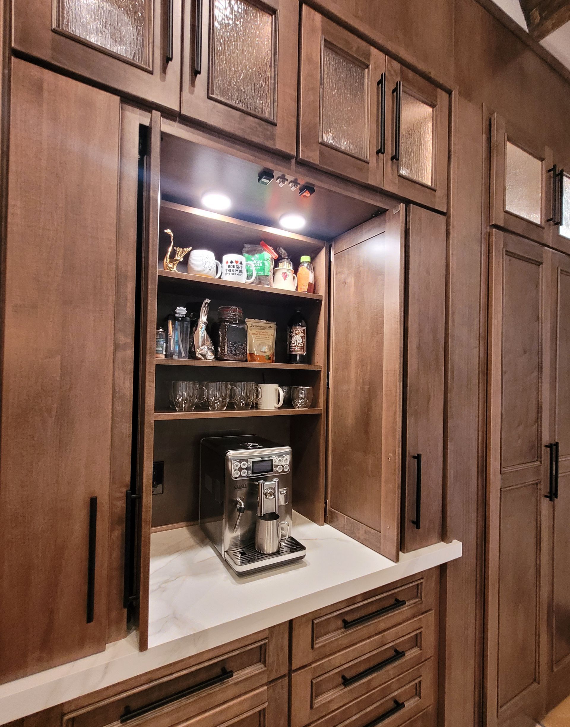 Open kitchen cabinet with shelves, coffee maker, and jars on a countertop.