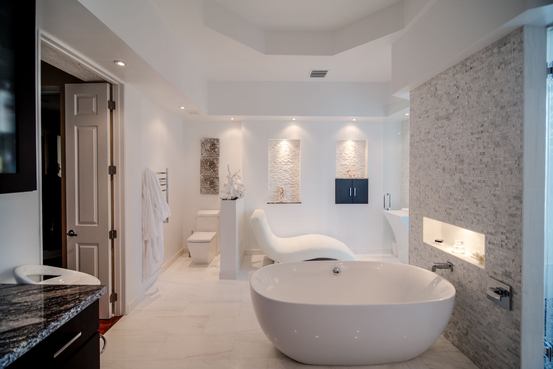 Modern white bathroom with freestanding tub, walk-in shower, and built-in wall niches