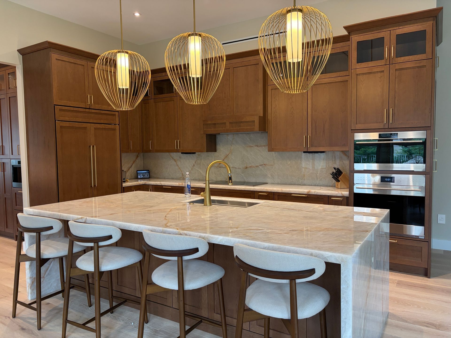 Kitchen remodel in Davie FL with quartzite waterfall island, custom wood cabinets and brass pendant lights