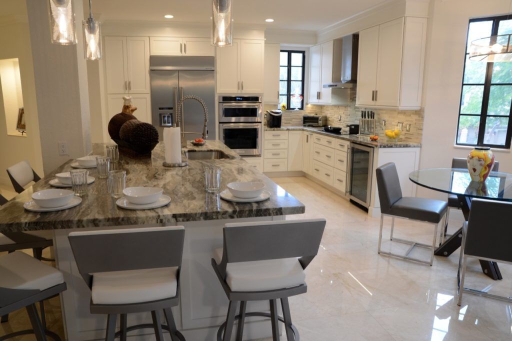 Modern kitchen and dining area with a large island, set table, and bright natural light