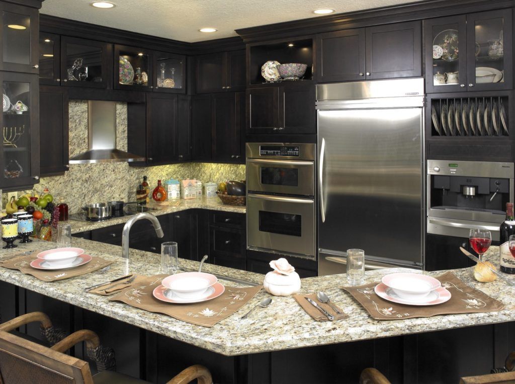 Modern kitchen with dark cabinets, granite island, and stainless steel appliances